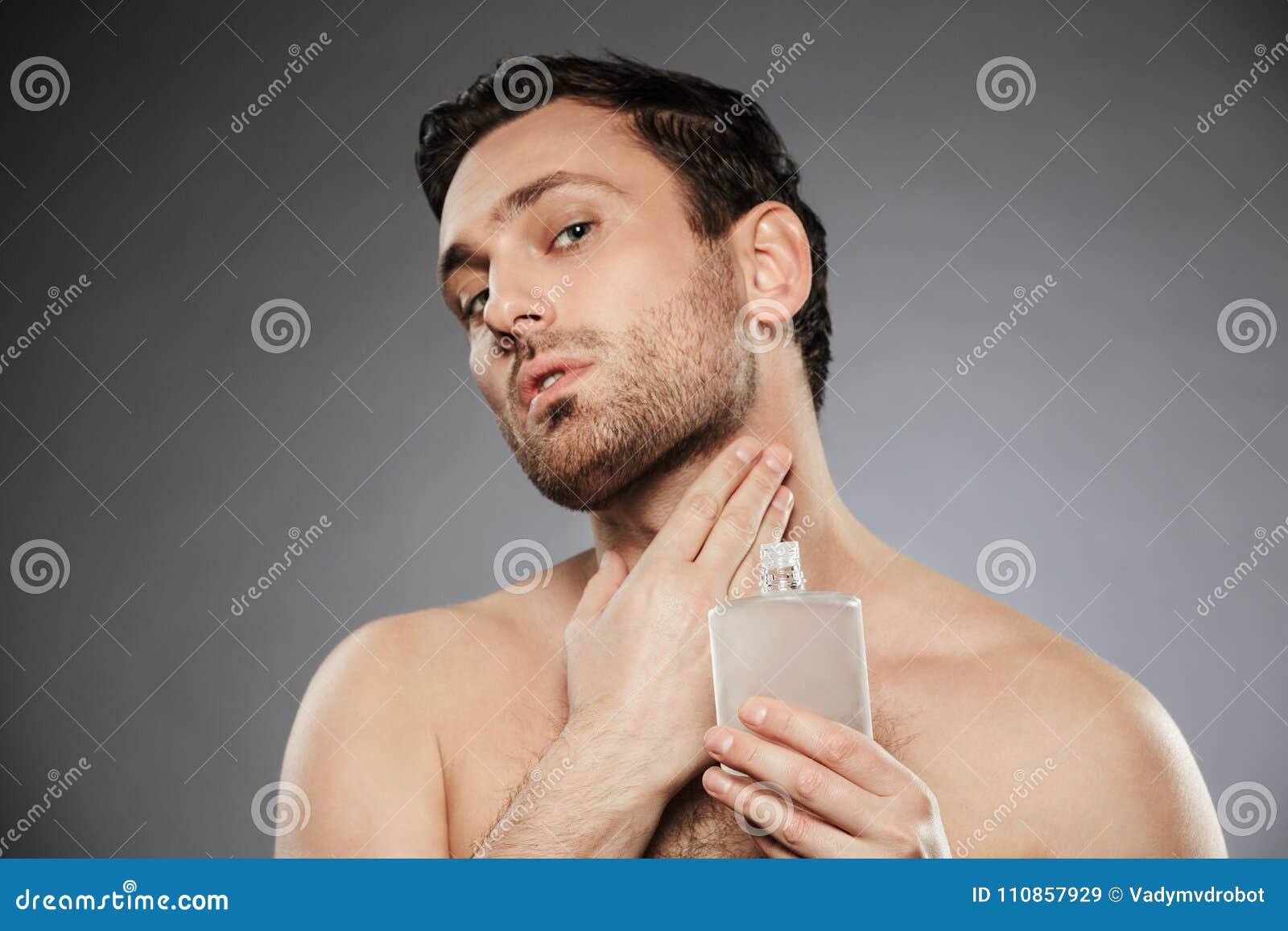 portrait of masculine sexual man putting perfume aftershave on h
