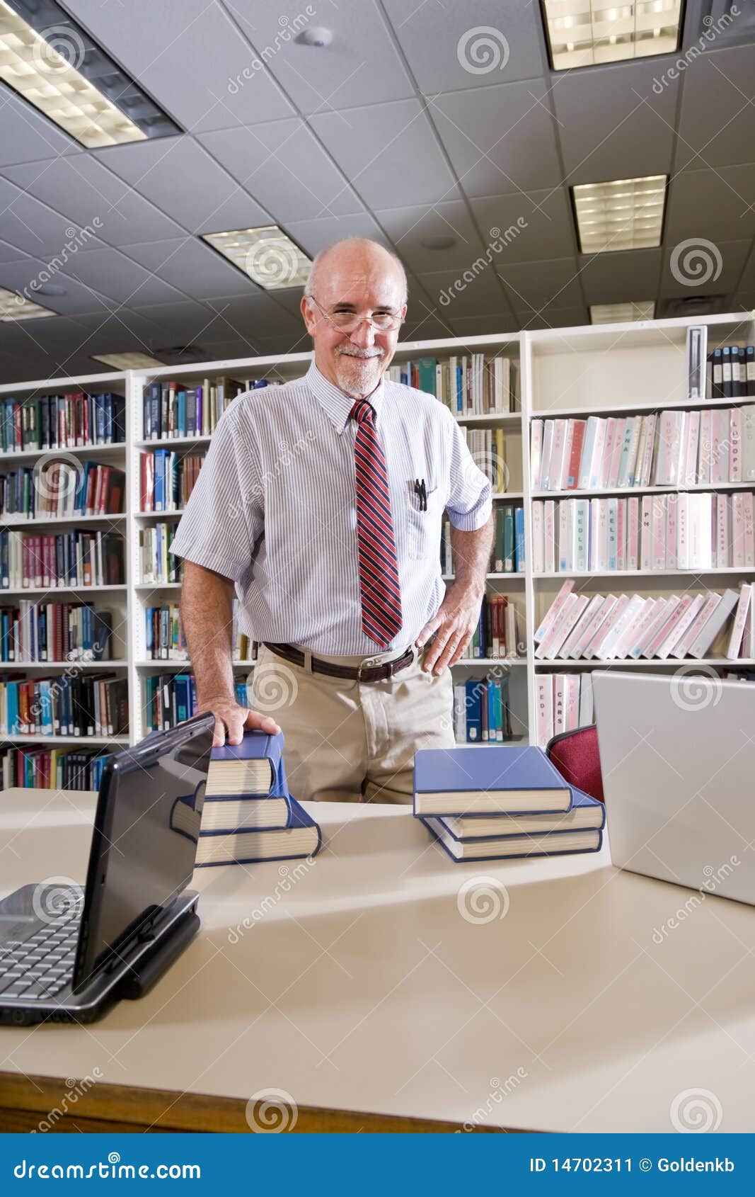 portrait of mature man at library with textbooks