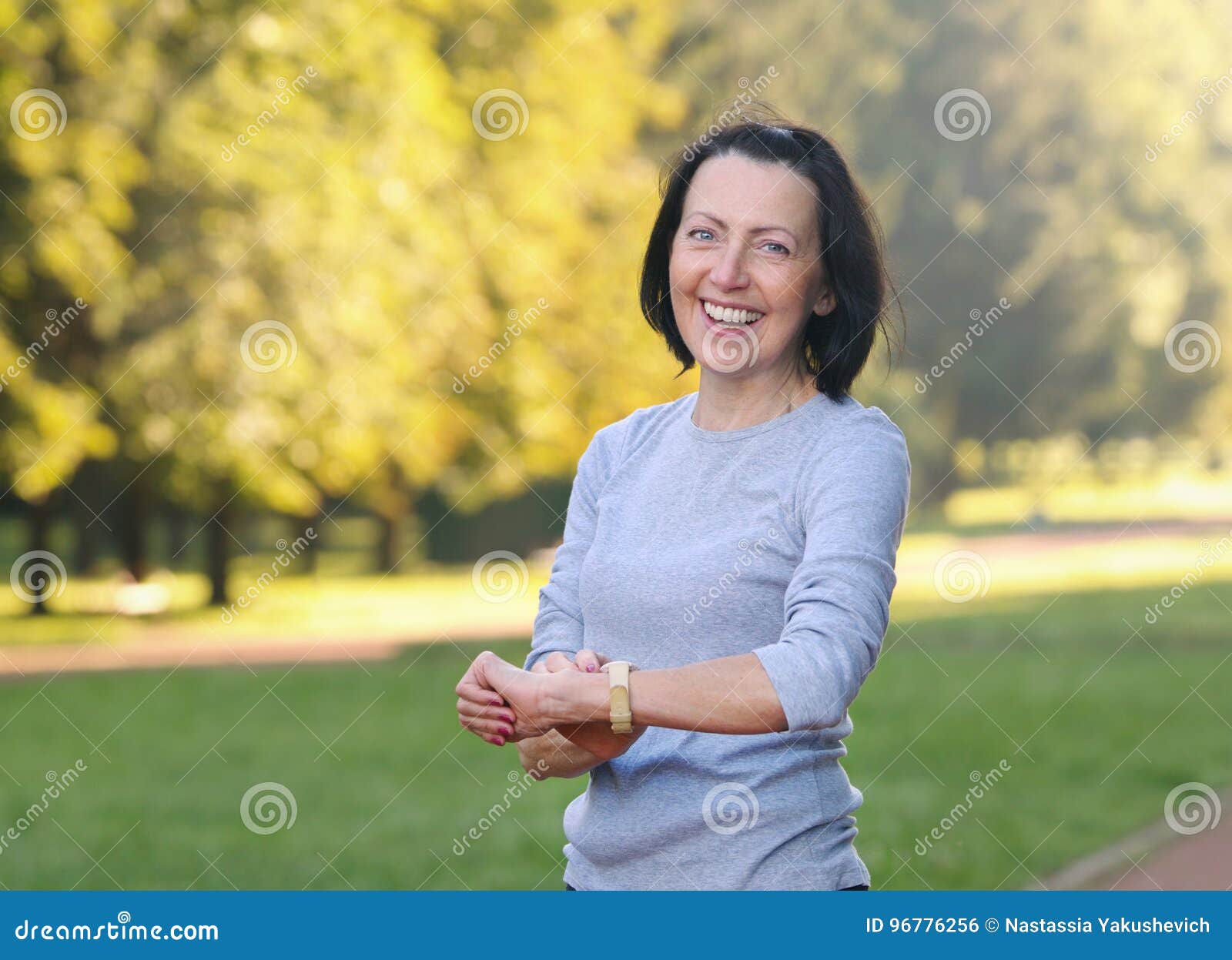 portrait of mature woman cheking the pulse after jog in the park