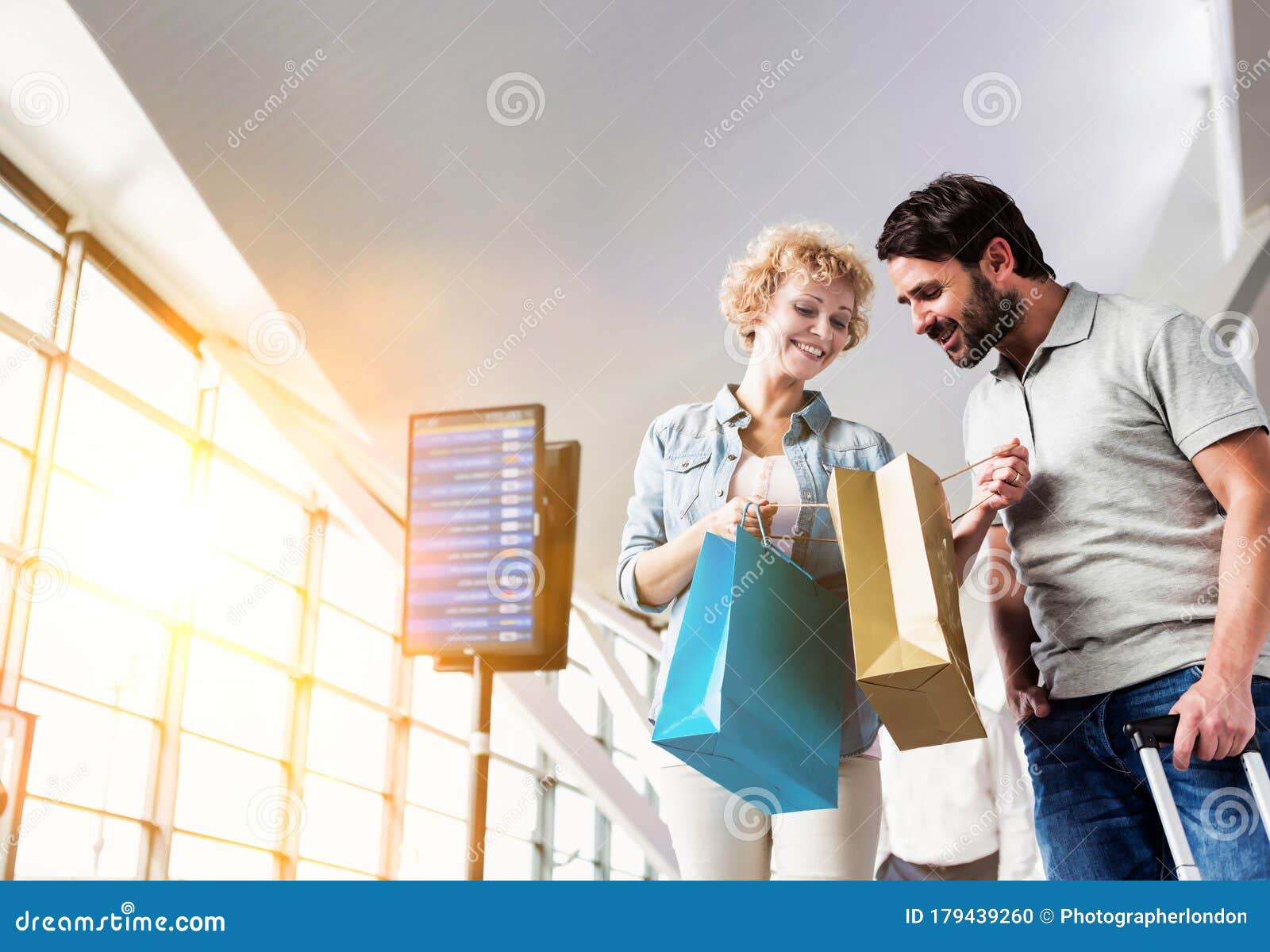 portrait of mature woman showing present she bought in duty free with her husband at airport