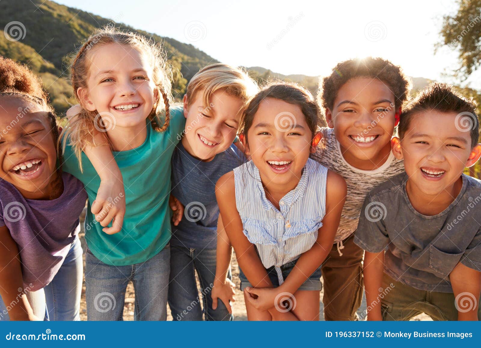 portrait of multi-cultural children hanging out with friends in countryside together