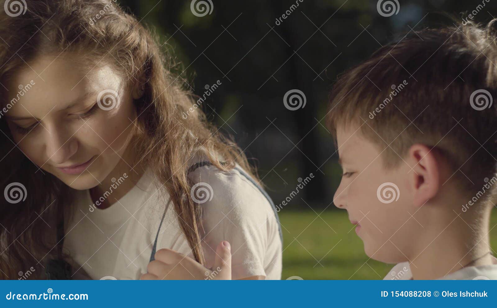 Portrait Of Older Sister Spending Time With Younger Brother Outdoors