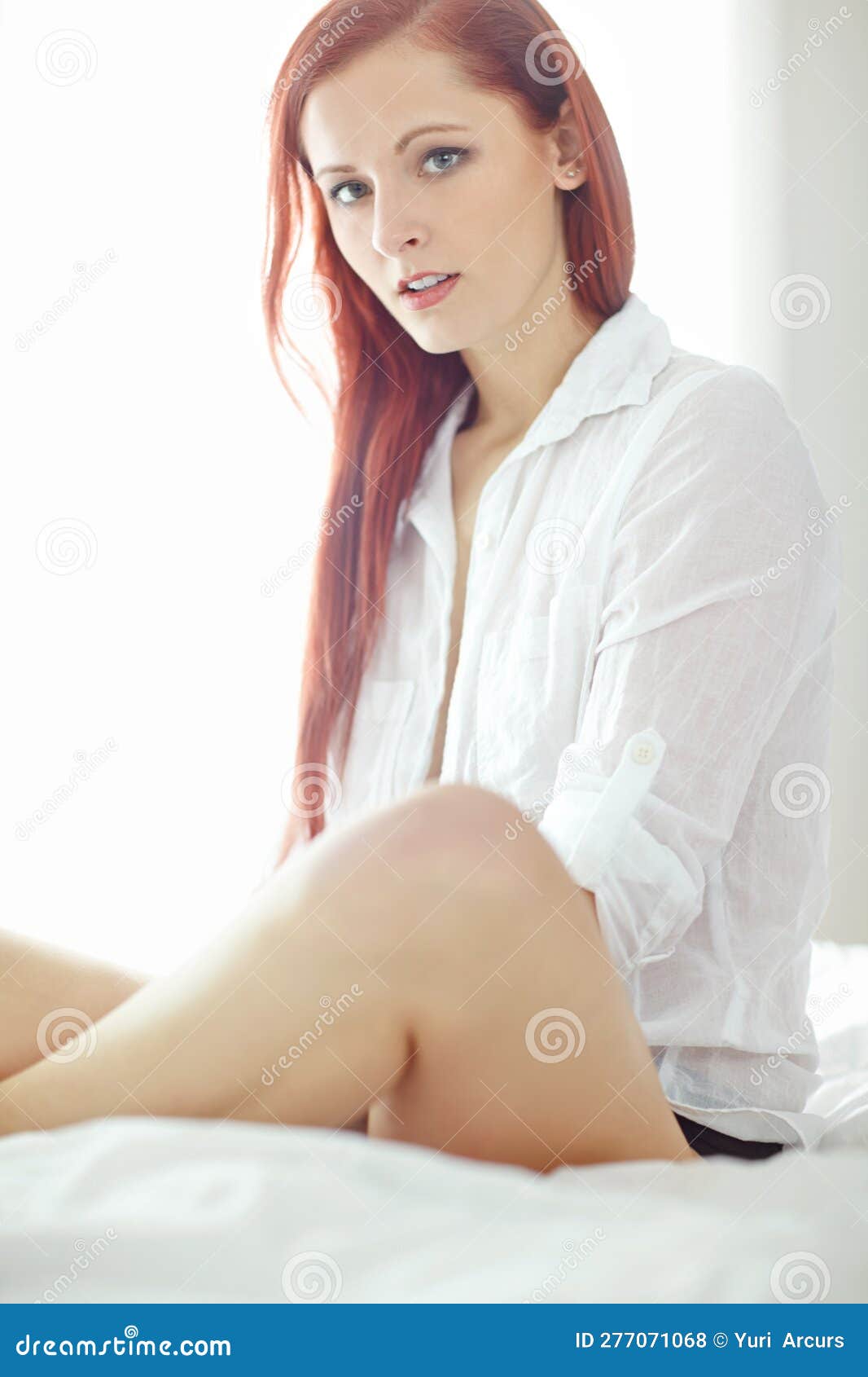Portrait of One Beautiful Young Redhead Woman Relaxing on a Bed at