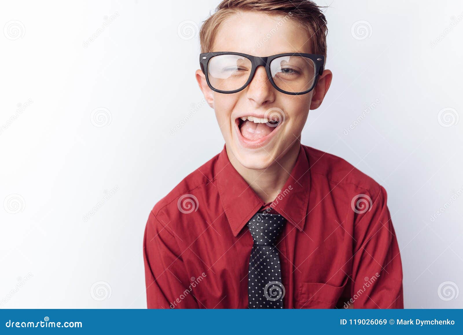 Portrait of a positive teenager on a white background, glasses, red shirt, advertising, text insert