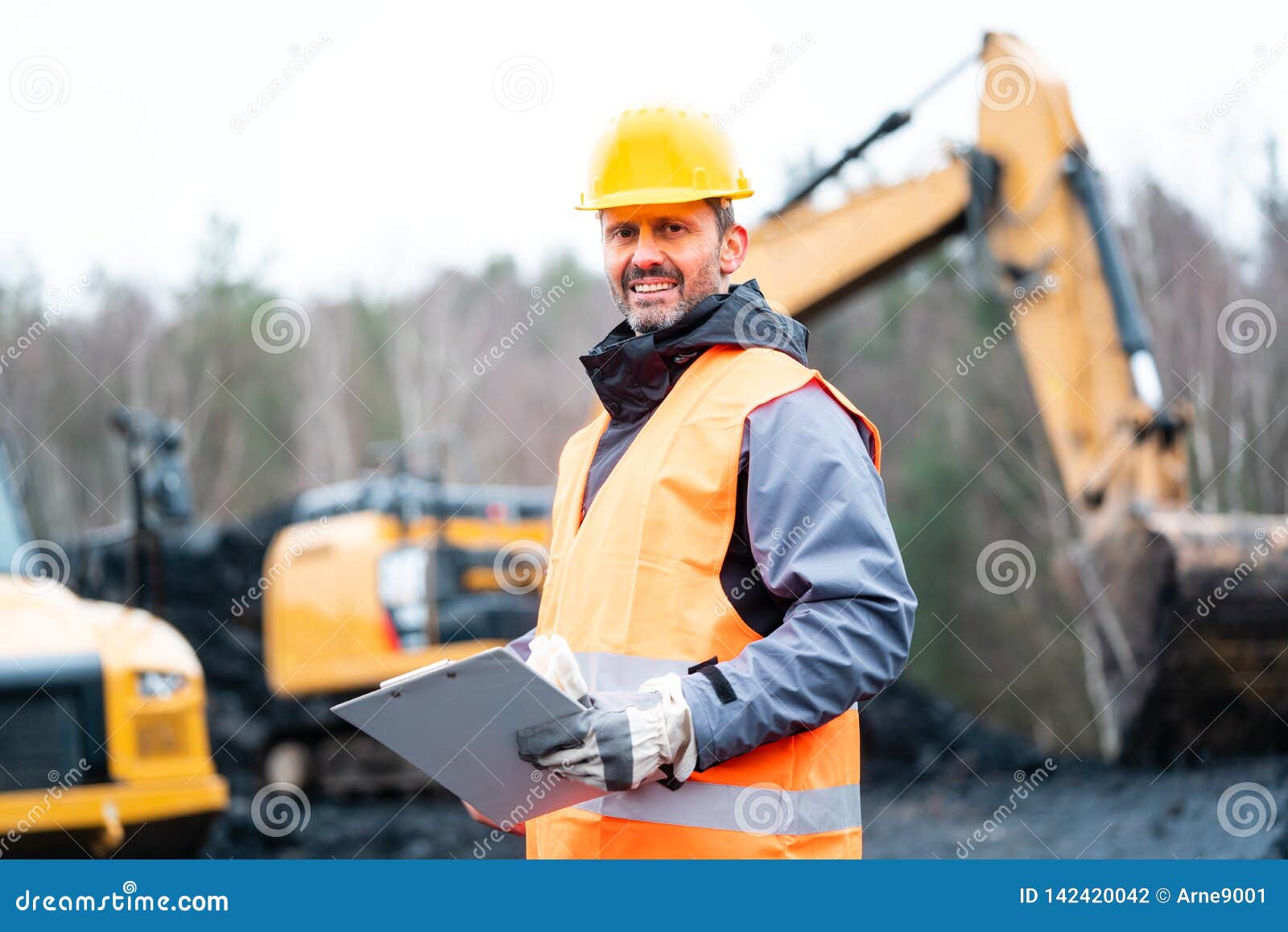 Portrait of a Quarry Worker Standing in Front of Excavator Stock Photo