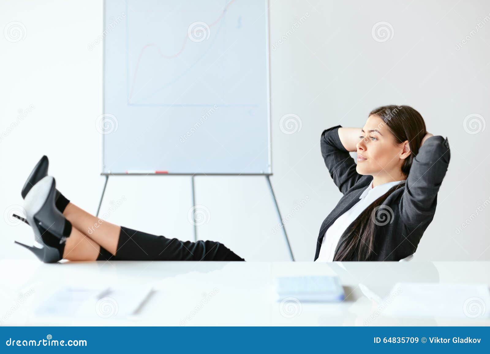portrait of relaxed business woman sitting with legs on desk