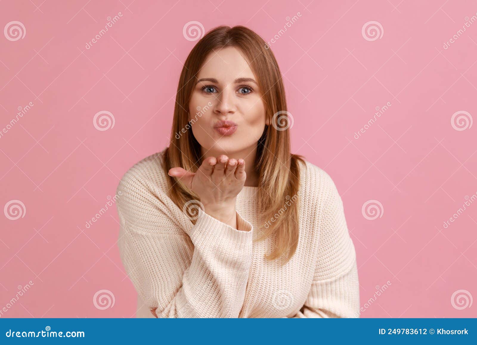 blond woman sending air kiss over palms, expressing fondness, romantic feelings and flirt.