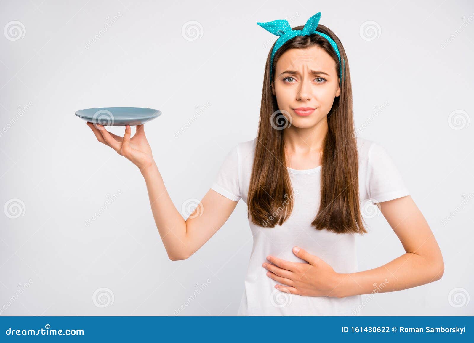 portrait of sad upset girl hold hand feel hungry have stomach ache want eat more unhealthy dieting concept hold plate