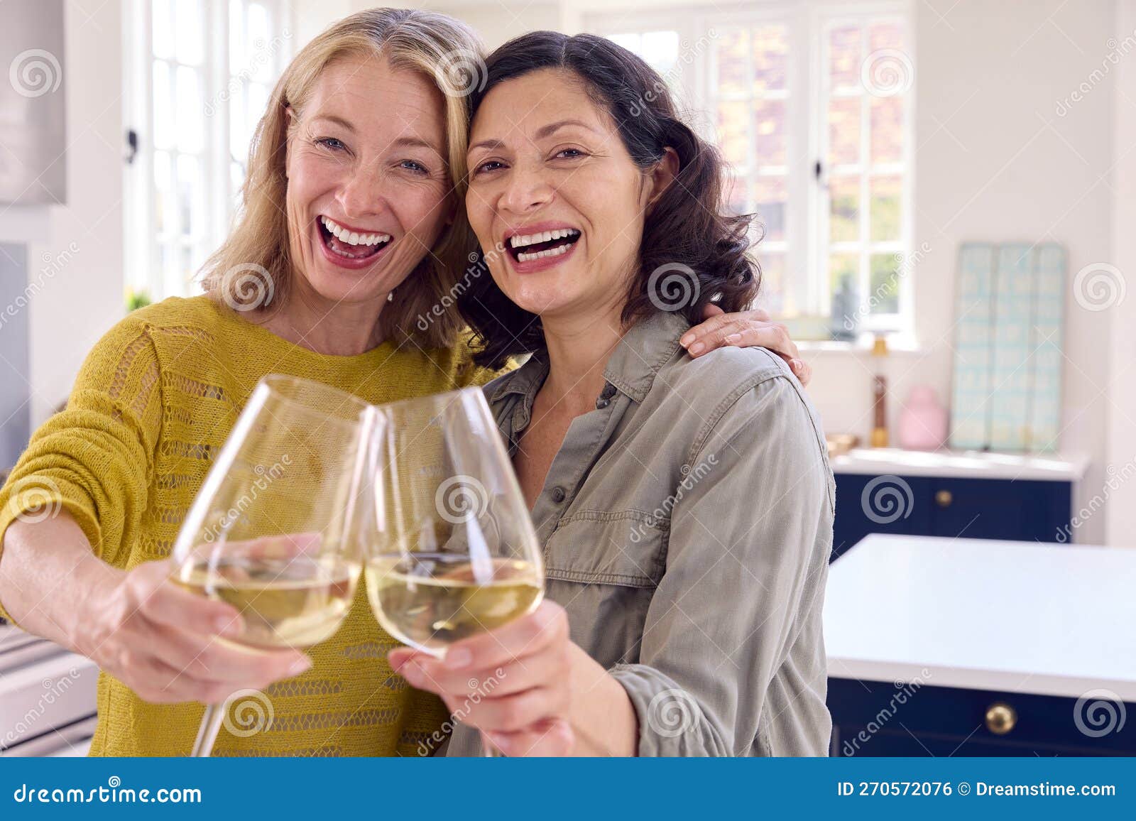 Portrait of Same Sex Mature Female Couple Celebrating with Glass of Wine at Home Together Stock Photo