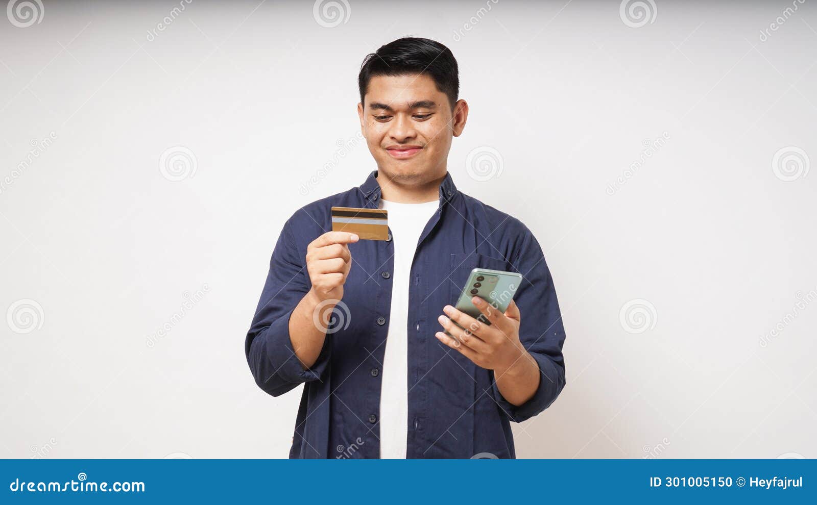 happy asian young man holding smart phone and credit card