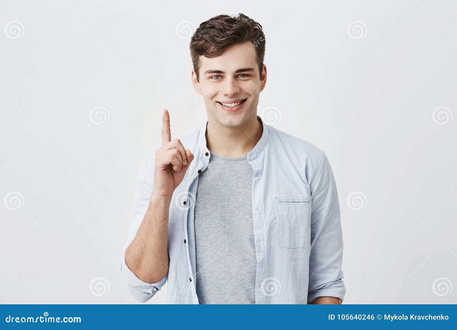 satisfied and pleased caucasian customer pointing with index finger up at blank space over head for your advertisment