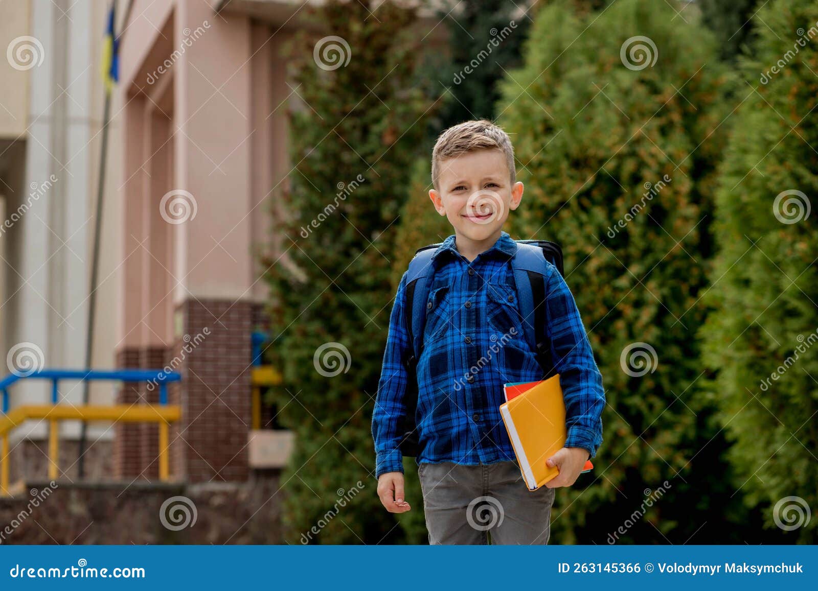 Portrait of Schoolboy in a Blue Shirt with a Backpack and Textbooks
