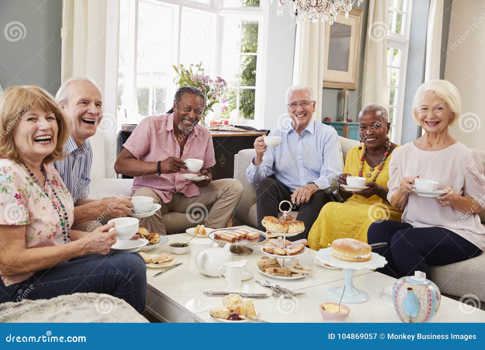 portrait of senior friends enjoying afternoon tea at home