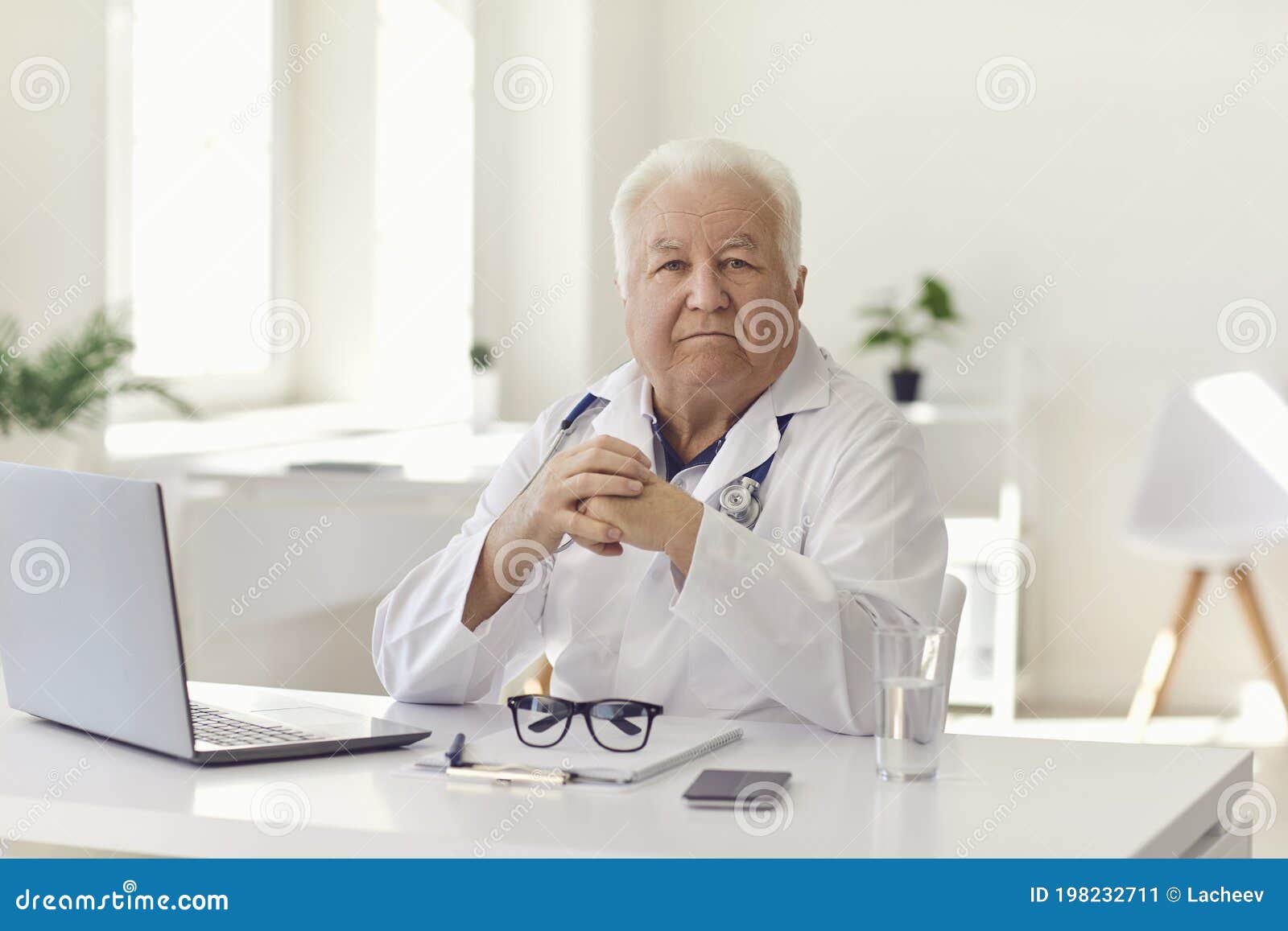 Serious Senior Physician Sitting at Desk with Laptop in Hospital Office ...