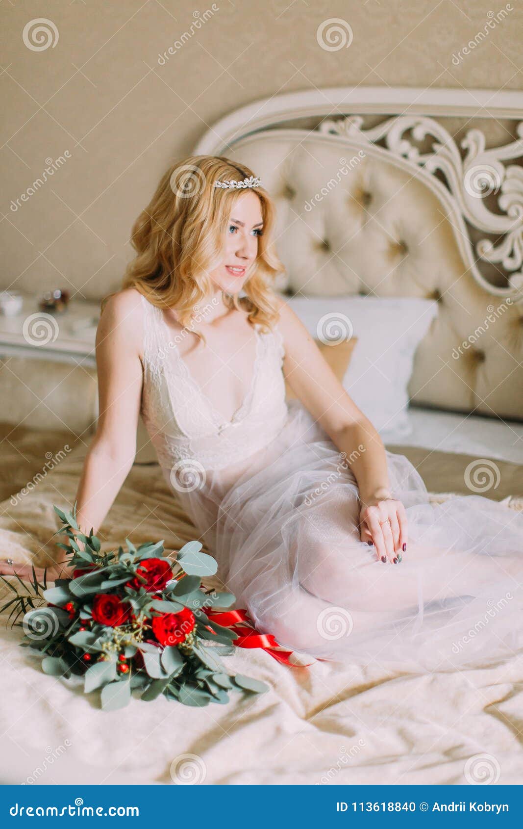 Portrait Of Blonde Bride In White Underwear Sitting On Bed