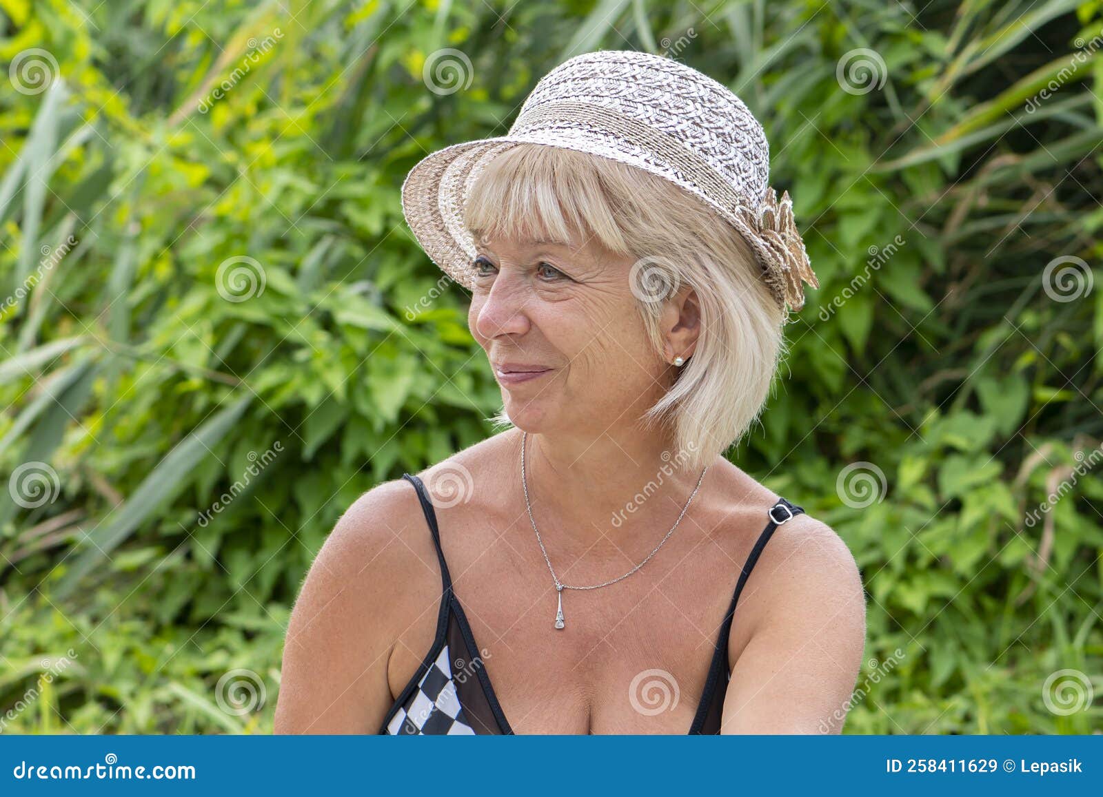 Portrait Of A Elderly Woman 60 65 Years Old In A Straw Hat And Swimsuit