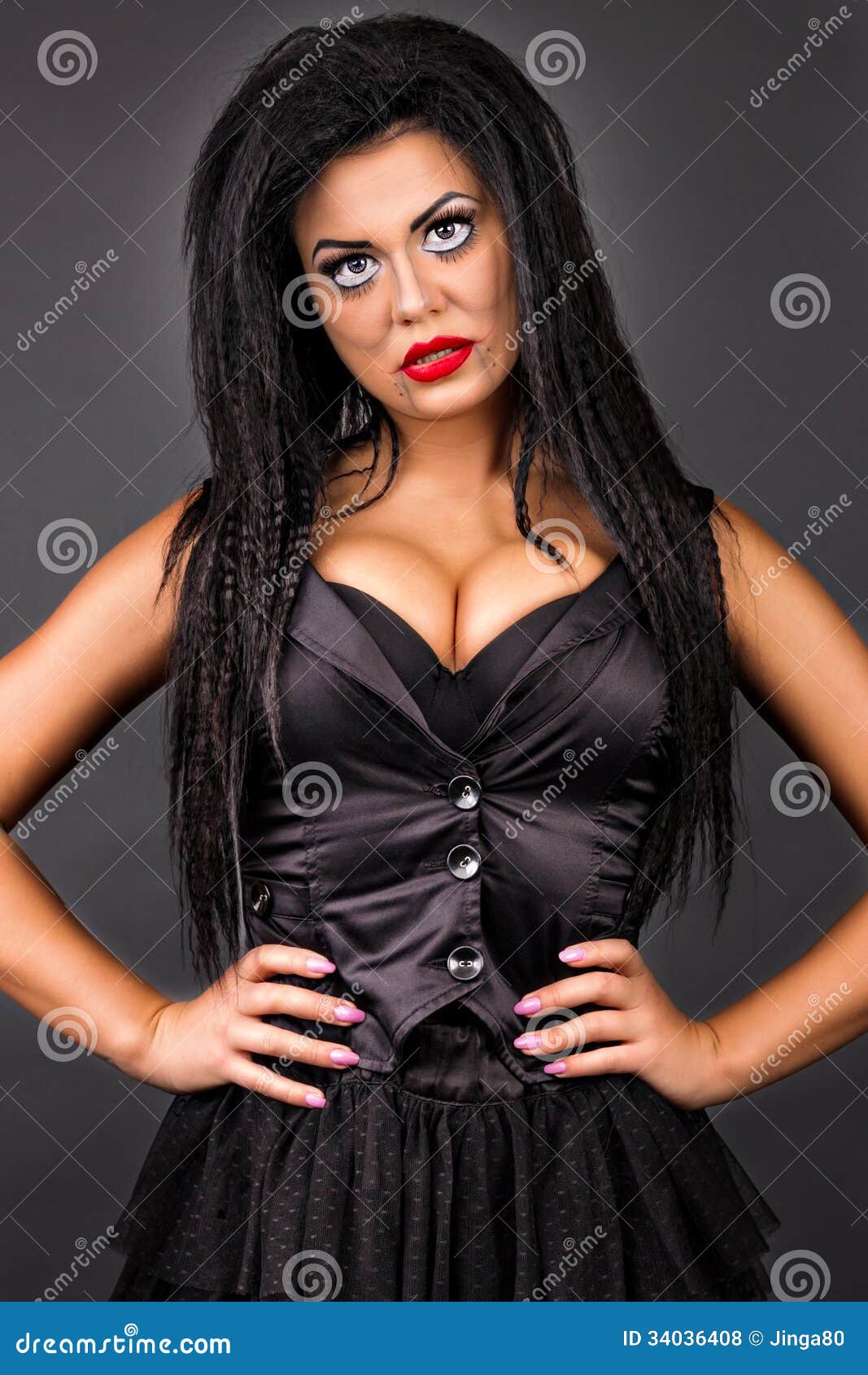 Portrait of a young woman with creative make-up holding her hair with hands on gray background