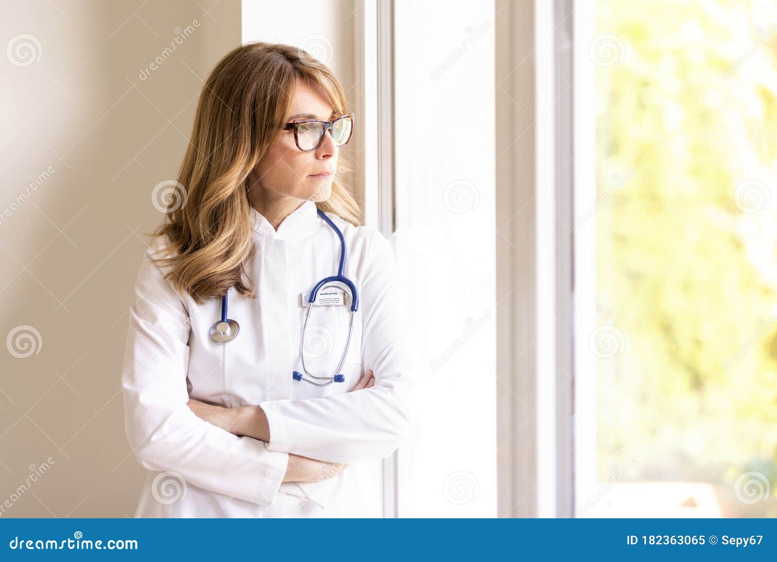 thinking female doctor looking out the window