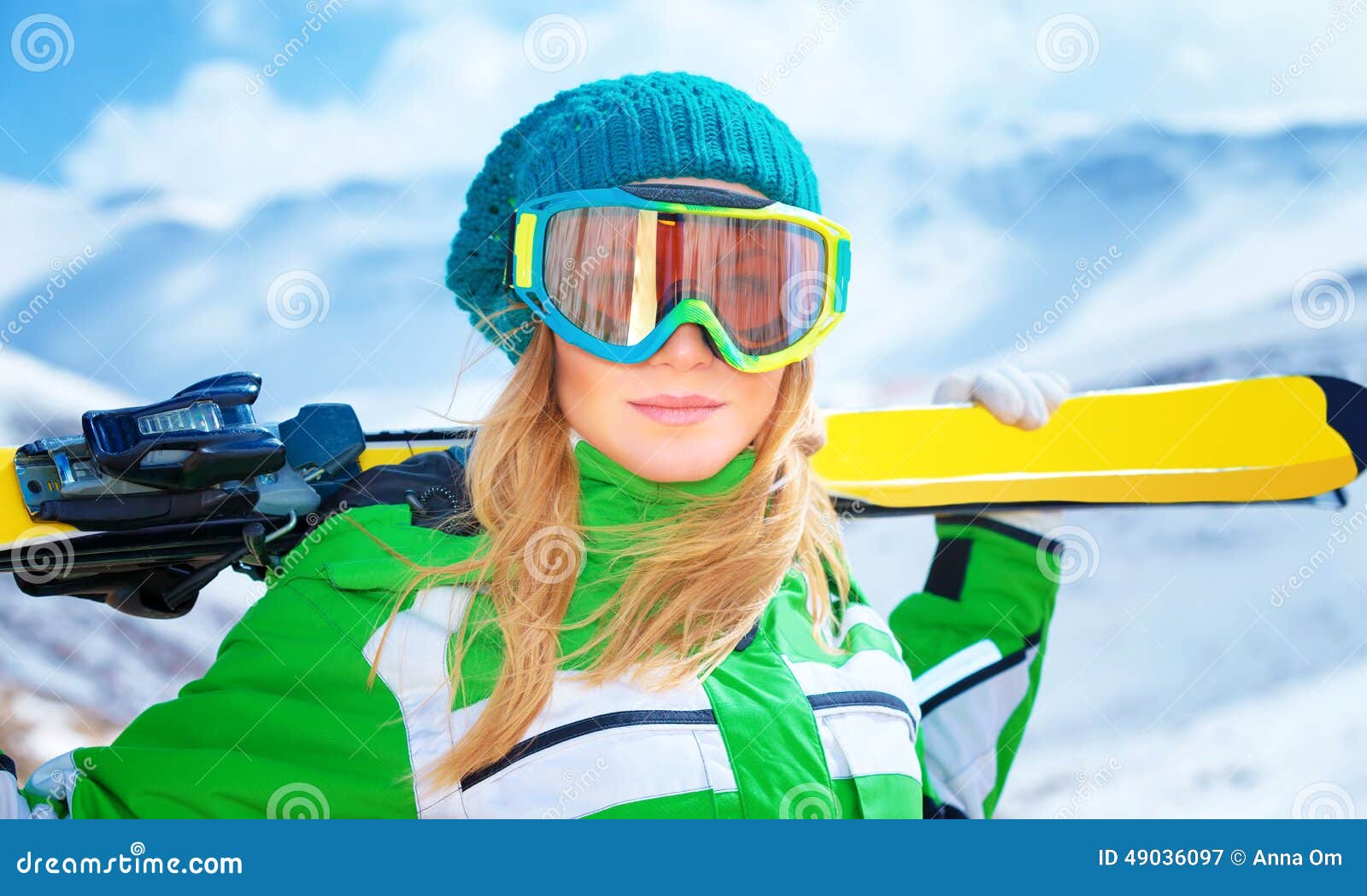 Portrait of skier girl. Closeup portrait of cute ski trainer, active woman wearing sportive goggles and holding in hands ski, active winter vacation, happiness and enjoyment concept