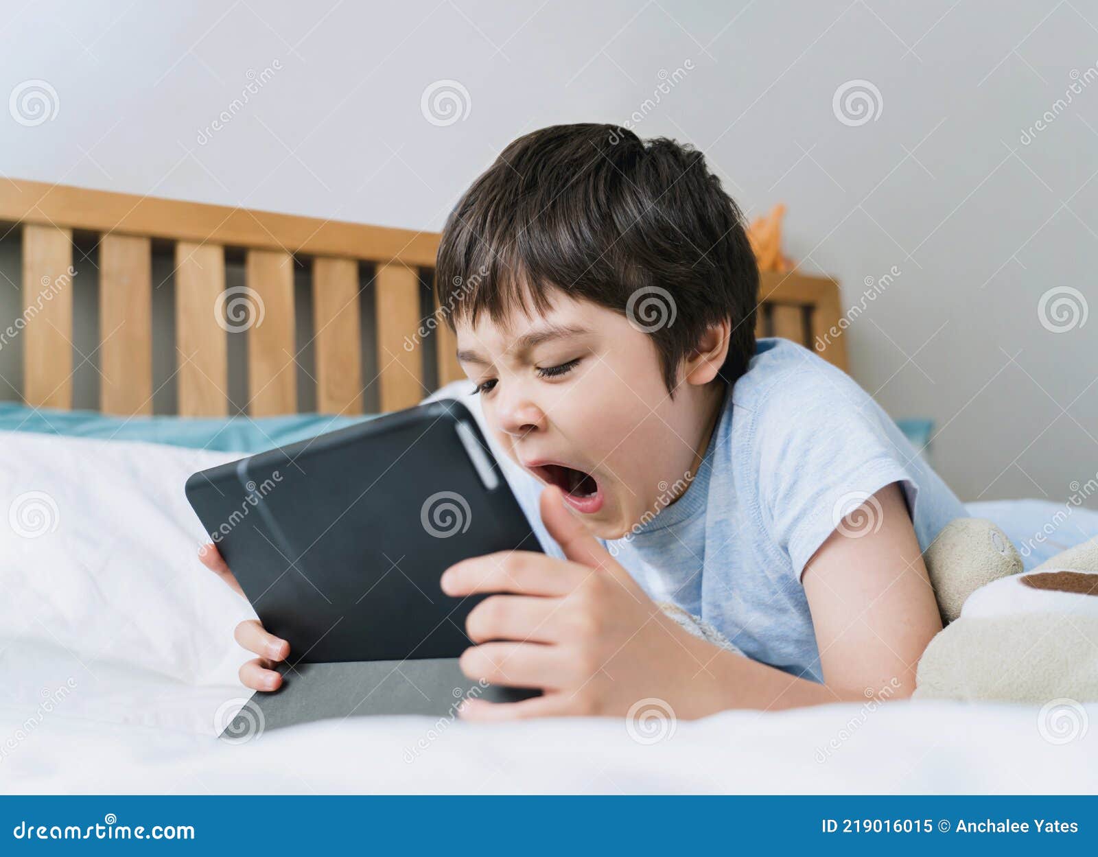 Portrait Sleepy Boy Yawning While Watching Cartoon Or Play Games On