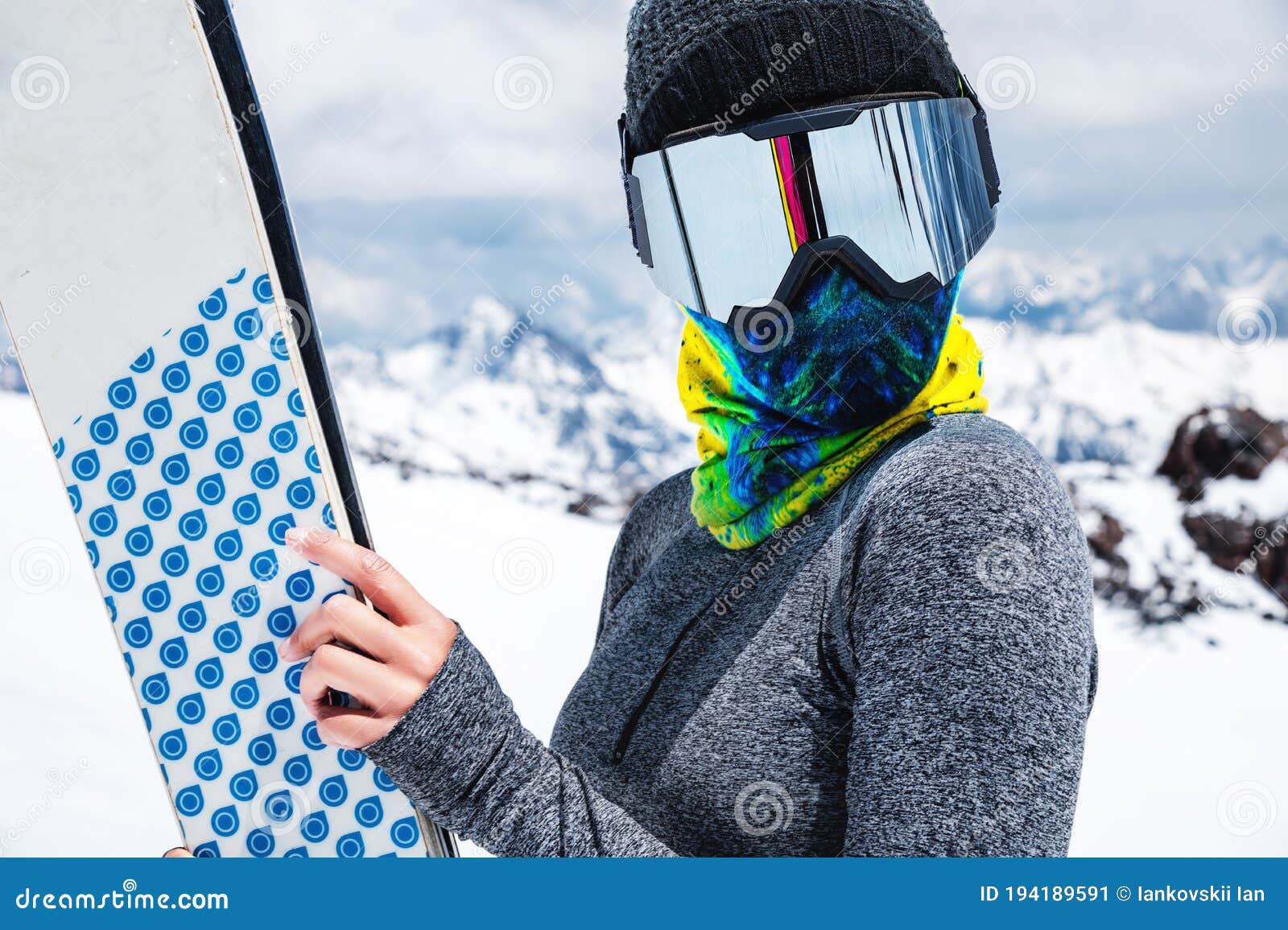 Portrait of a Slender Girl in a Buff and Balaclava in a Ski Mask and Hat  with a Closed Face Next To Skis on the Stock Image - Image of camera, girl: