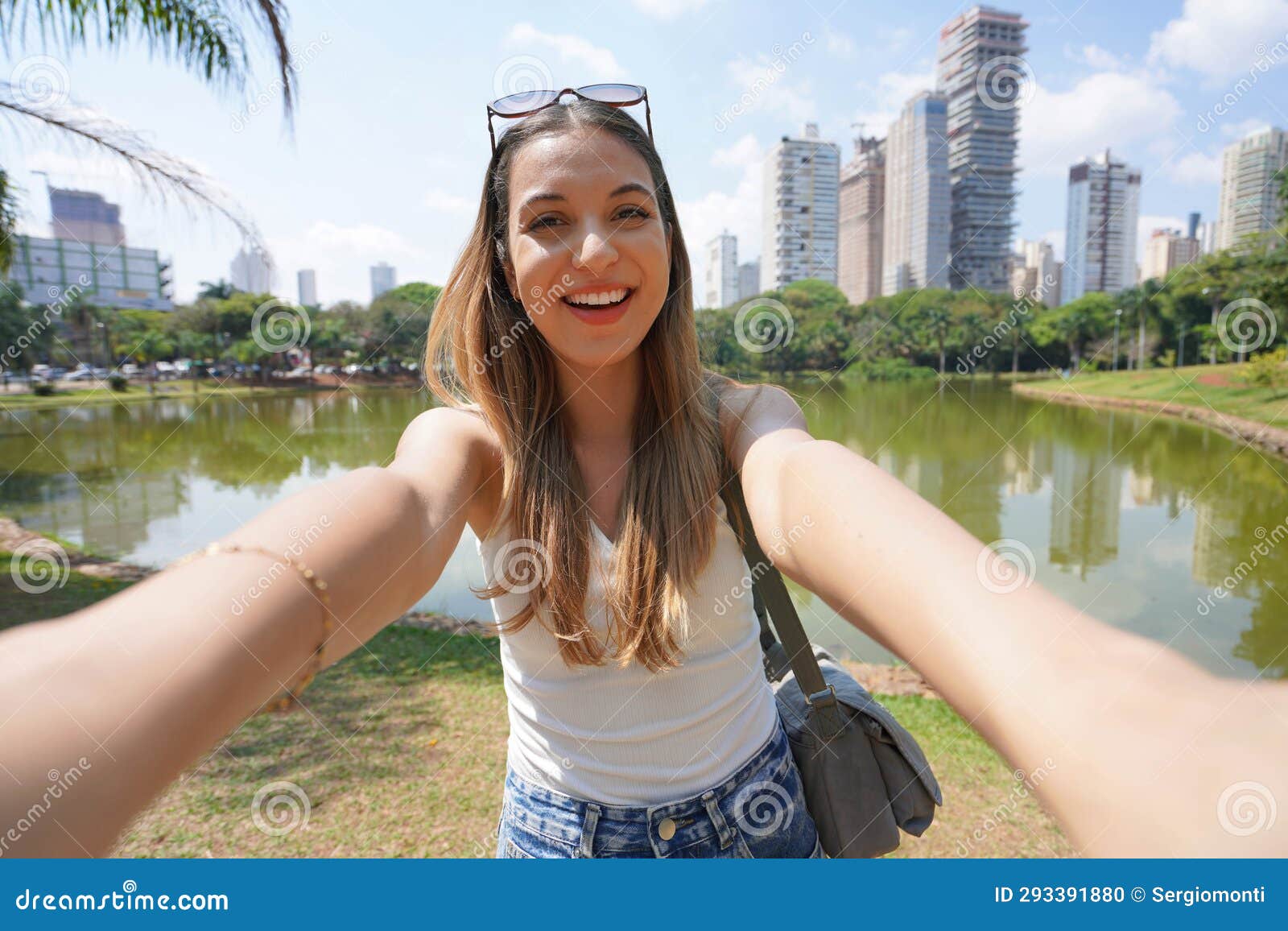 portrait of smiling brazilian girl takes selfie in vaca brava park in goiania, goias, brazil