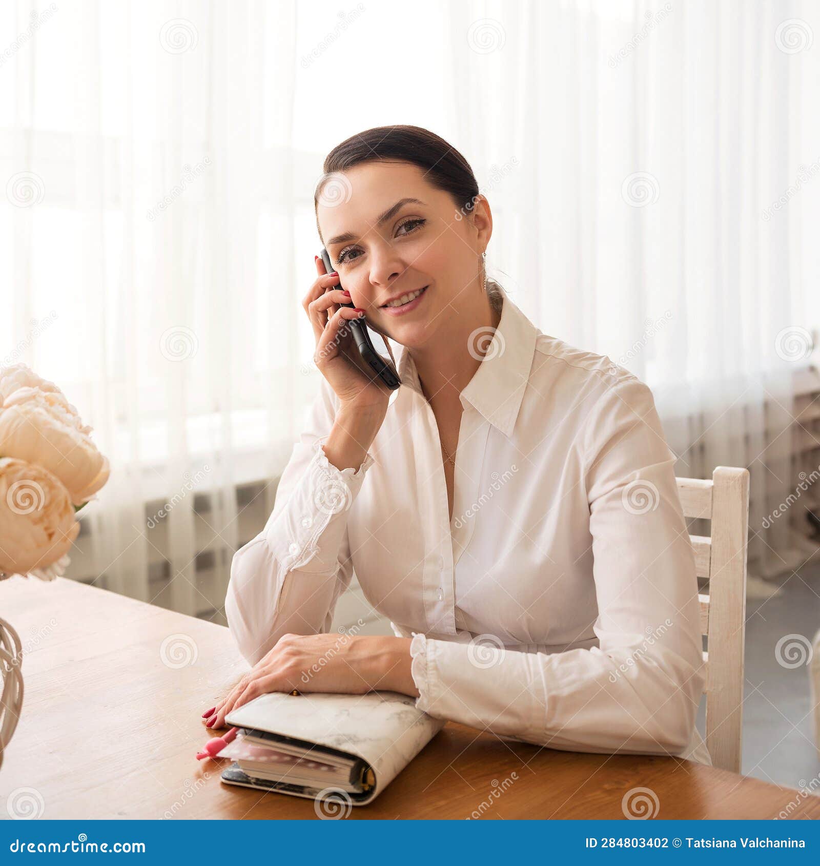portrait of a smiling businesswoman talking on phone at home