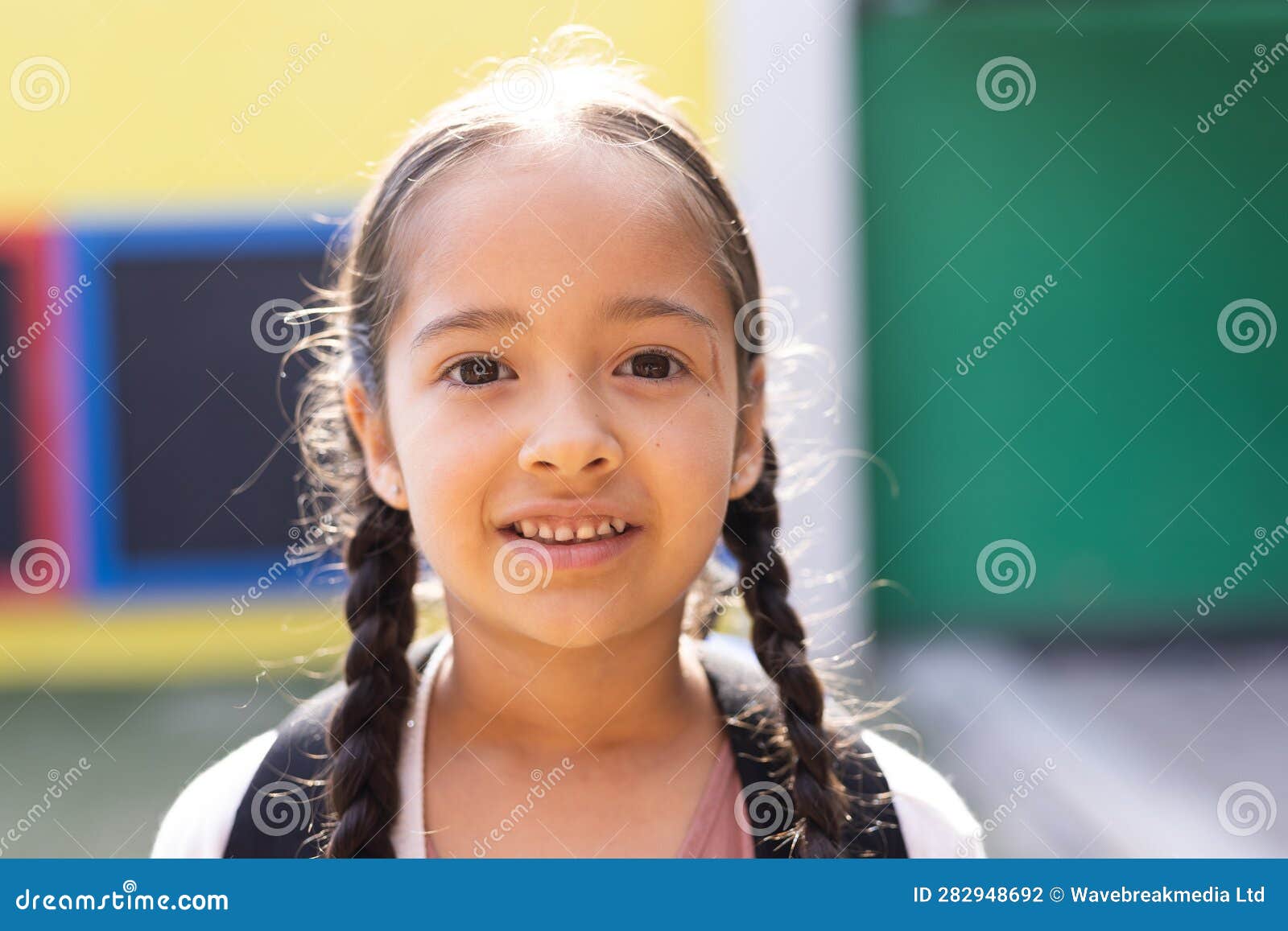 portrait of smiling cauasian ary schoolgirl in school playground, copy space