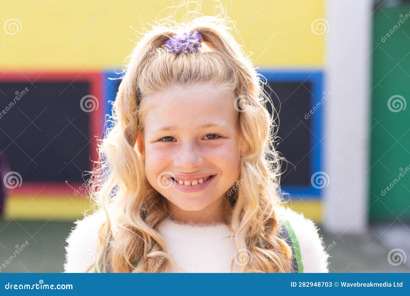 portrait of smiling cauasian ary schoolgirl in school playground, copy space