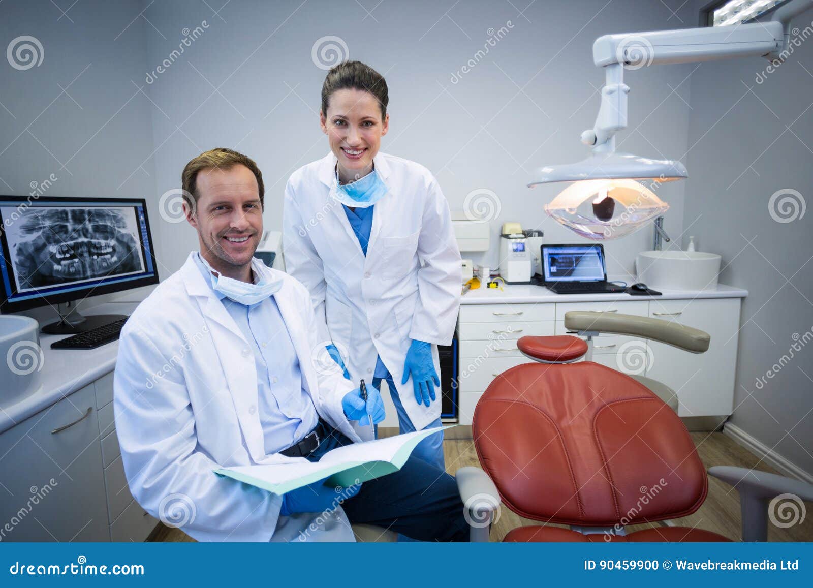 portrait of smiling dentists holding medical report