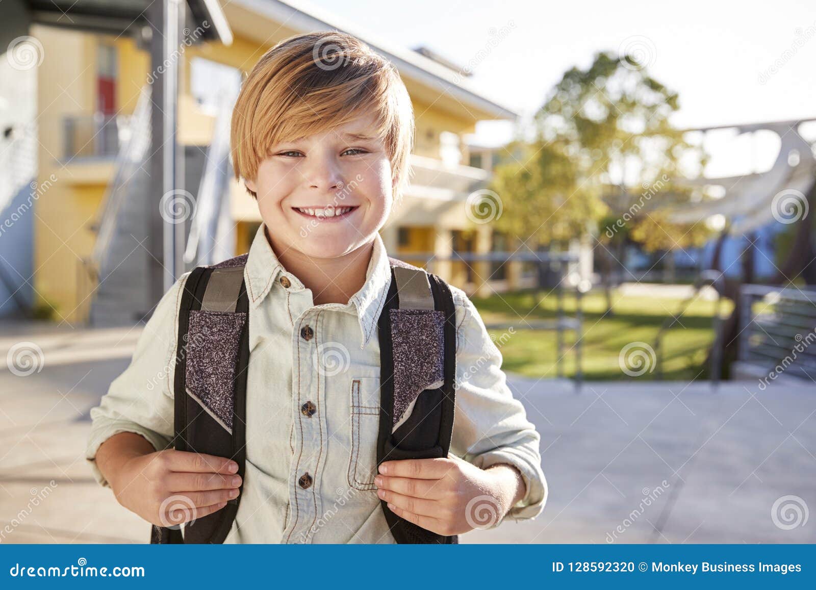 Portrait of Smiling Elementary School Boy with His Backpack Stock Photo