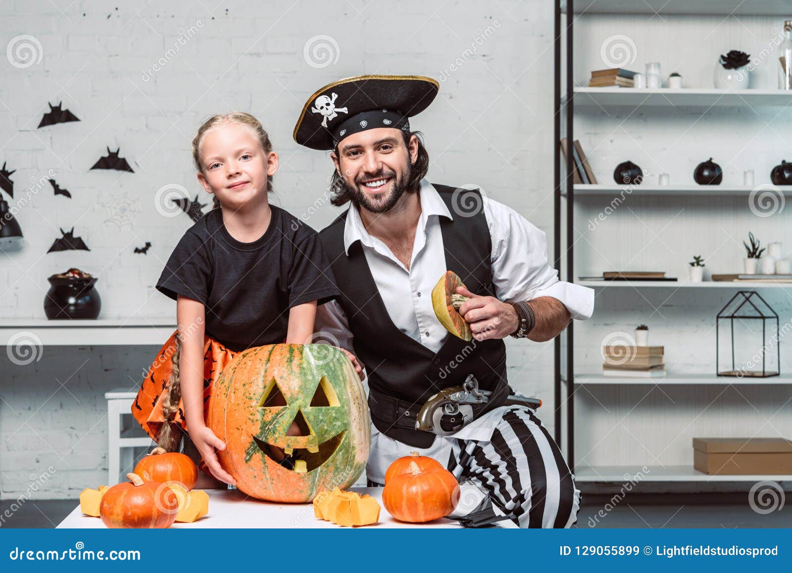 Portrait of Smiling Father and Daughter in Halloween Costumes at Table