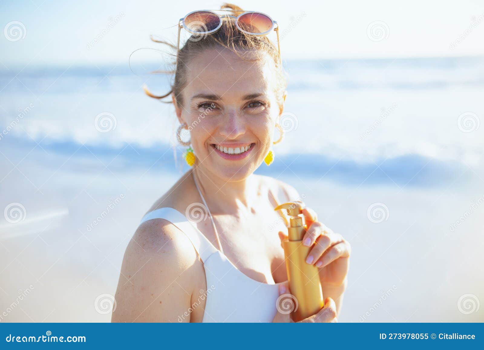Portrait of Smiling Female in Swimsuit at Beach Using Spf Stock Image