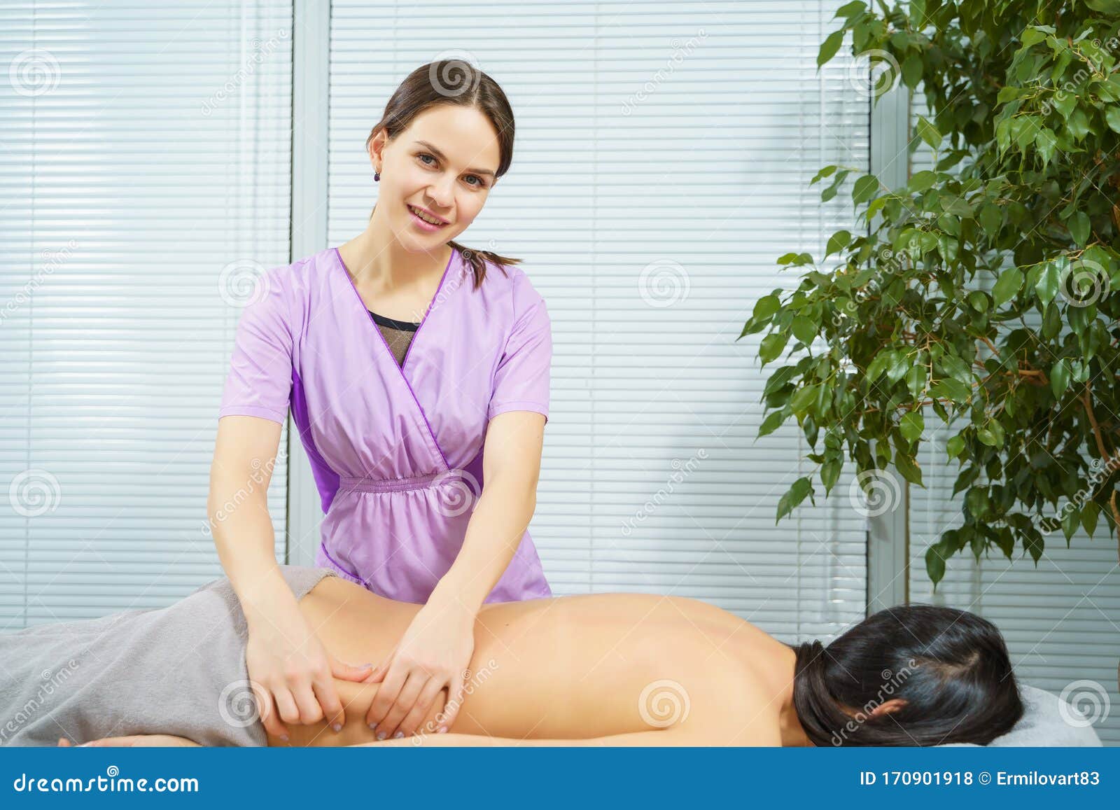 Portrait Of A Smiling Massage Therapist Woman Massaging A Yo
