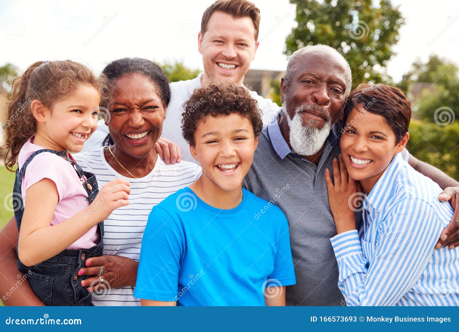 portrait of smiling multi-generation mixed race family in garden at home