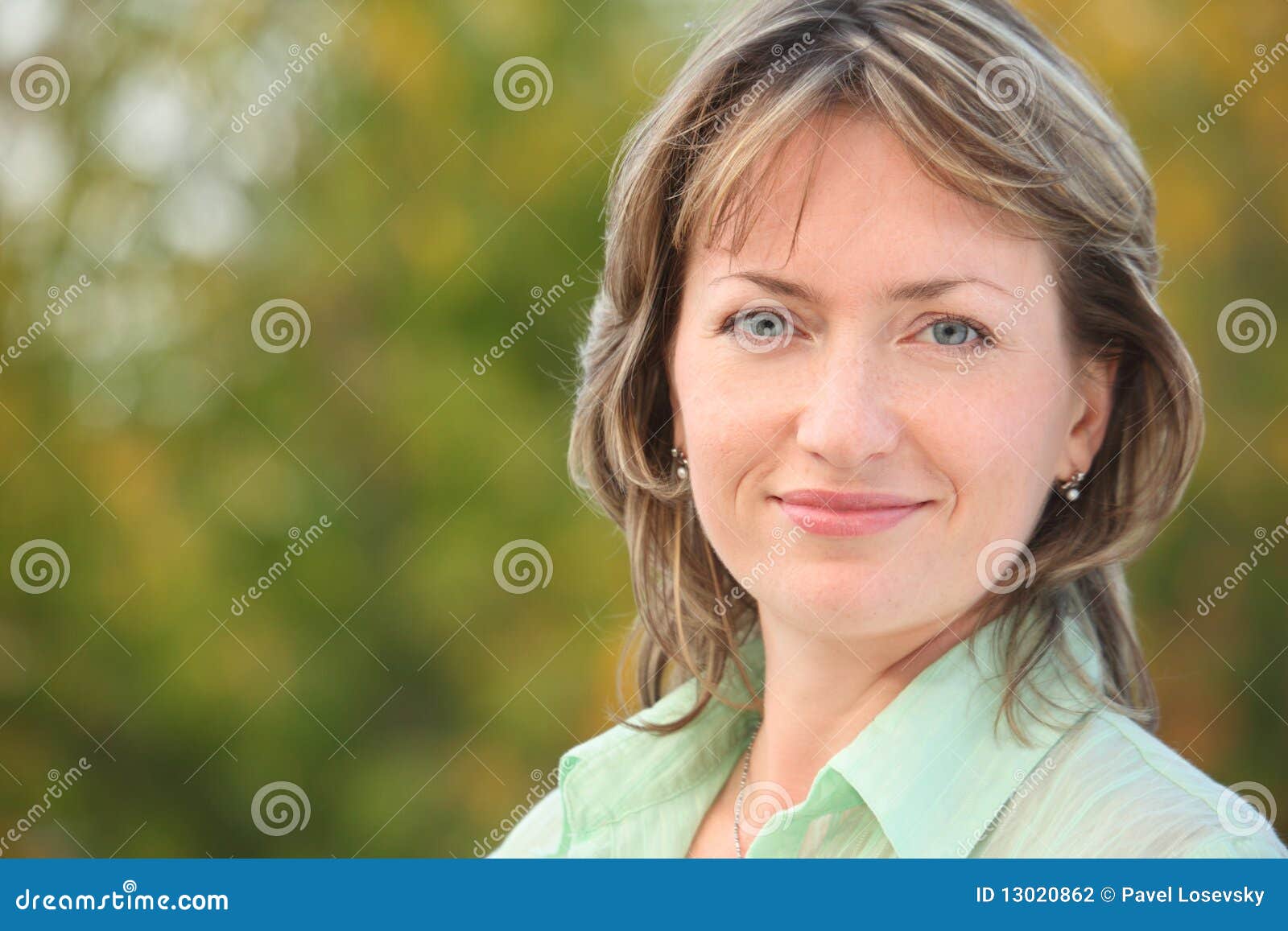 portrait of smiling woman in early fall park