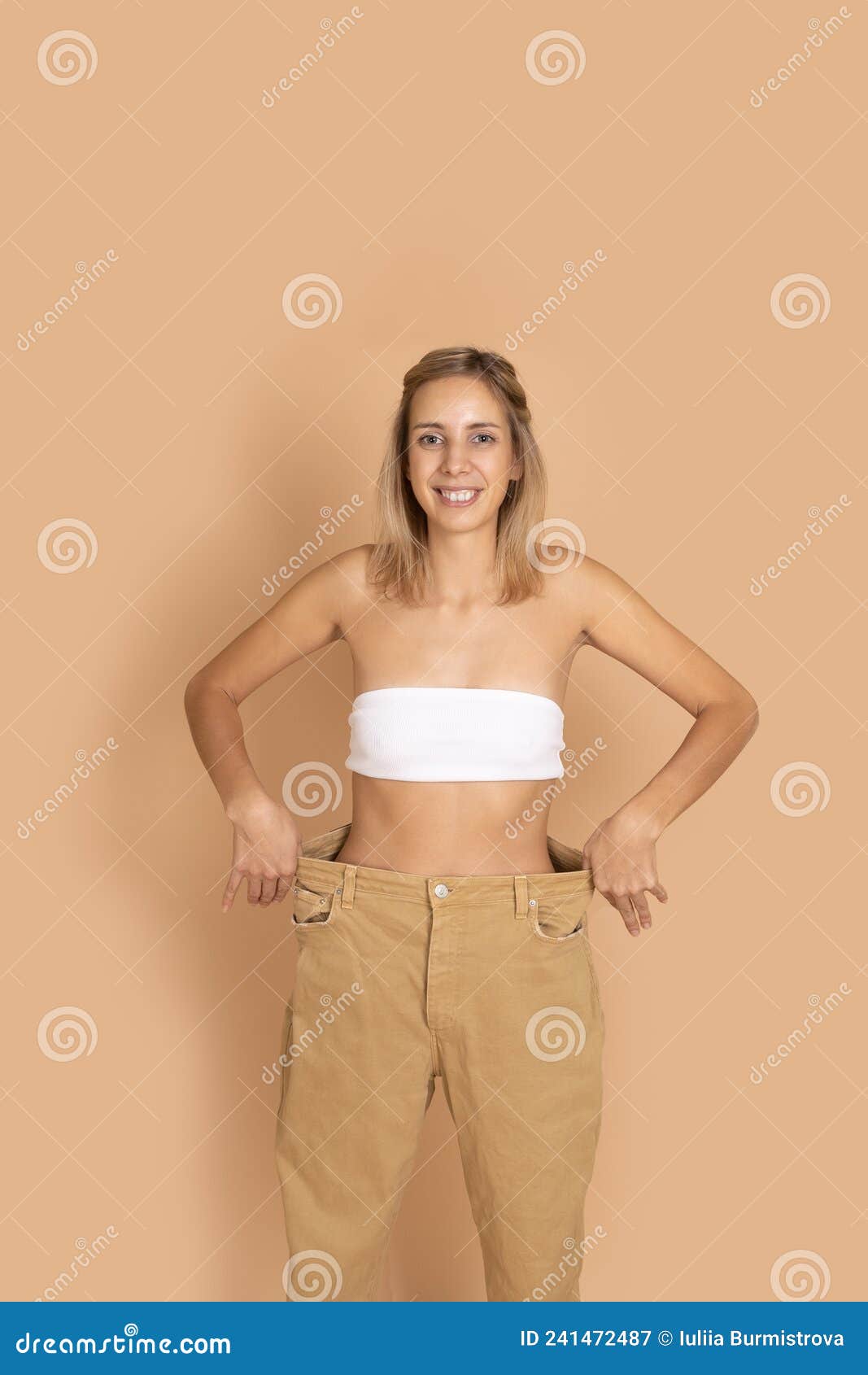 Portrait of Smiling Woman in Good Shape in Oversize Pants, White Underwear  Showing Slim Waist by Pulling Pants on Skin Stock Image - Image of female,  happy: 241472487