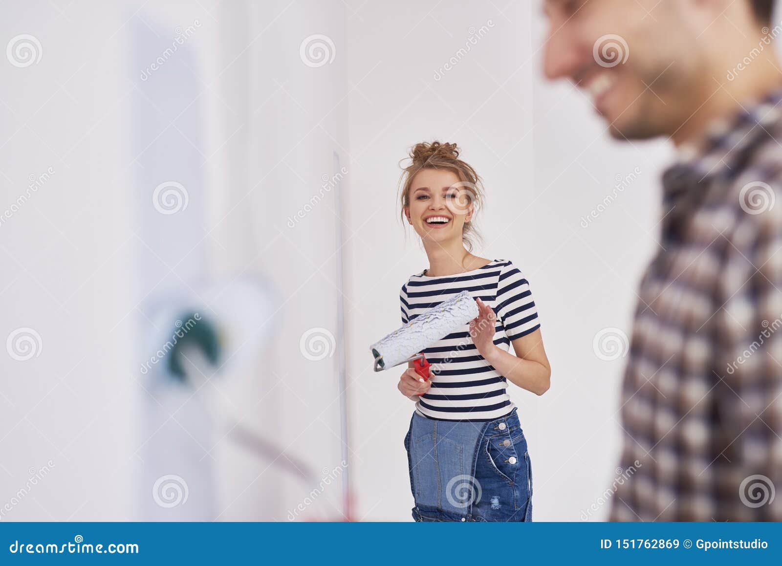 portrait of smiling woman painting walls in her new home