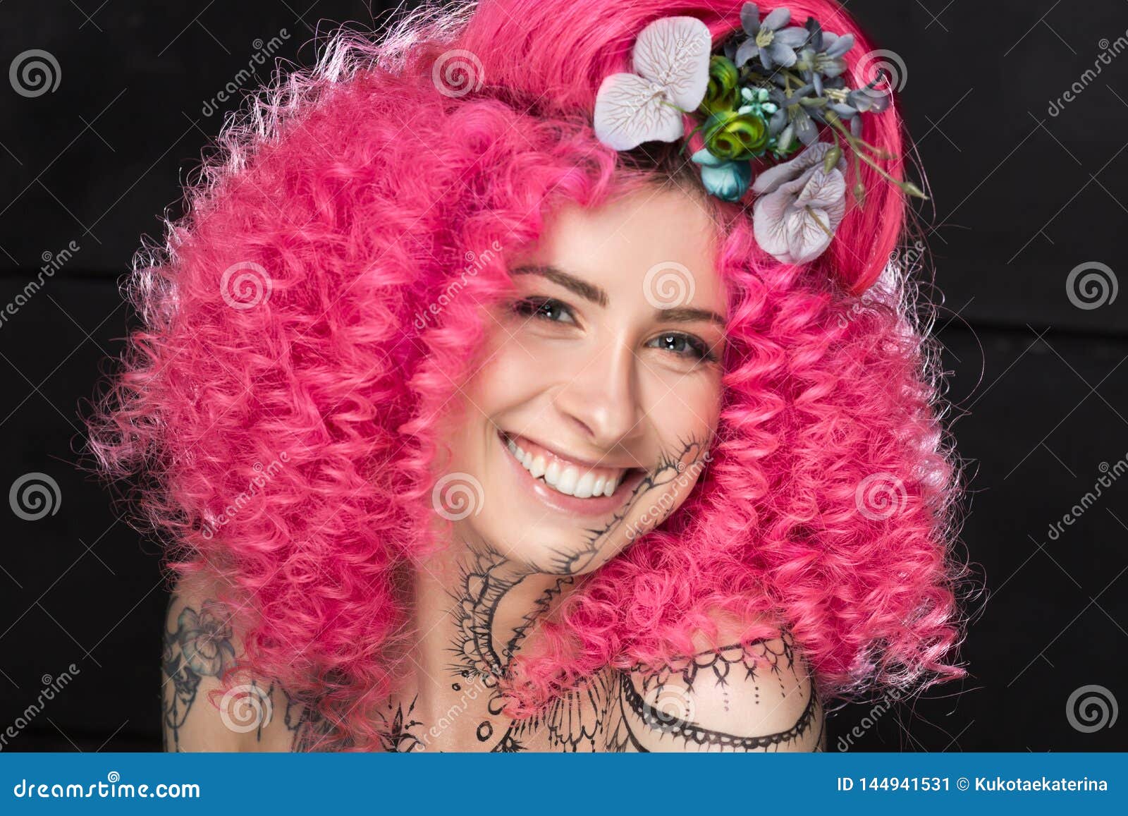 Portrait Of Smiling Young Attractive Caucasian Girl Model With Afro Style Curly Bright Pink Hair Tattooed Face And Flowers Woven Stock Image Image Of Caucasian Beauty 144941531
