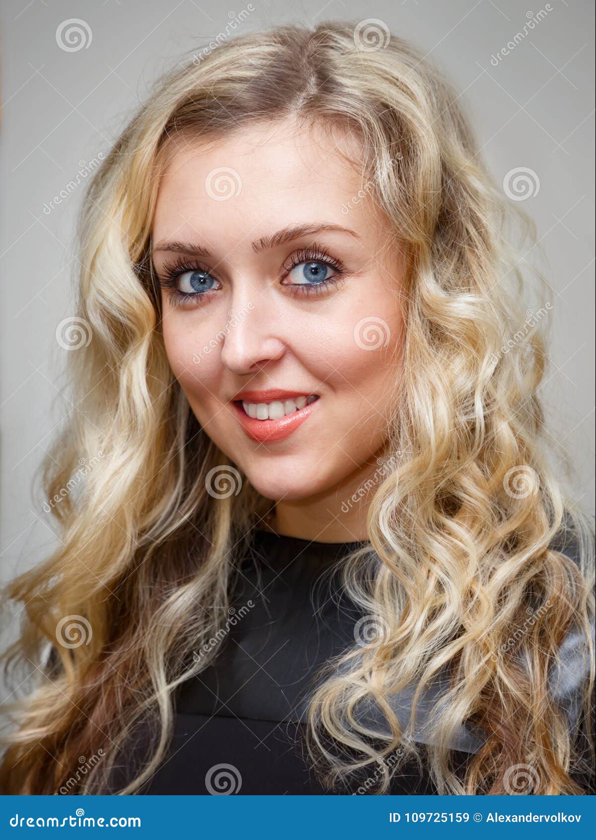 Portrait Of A Smiling Young Charming Woman With Long Wavy Blonde