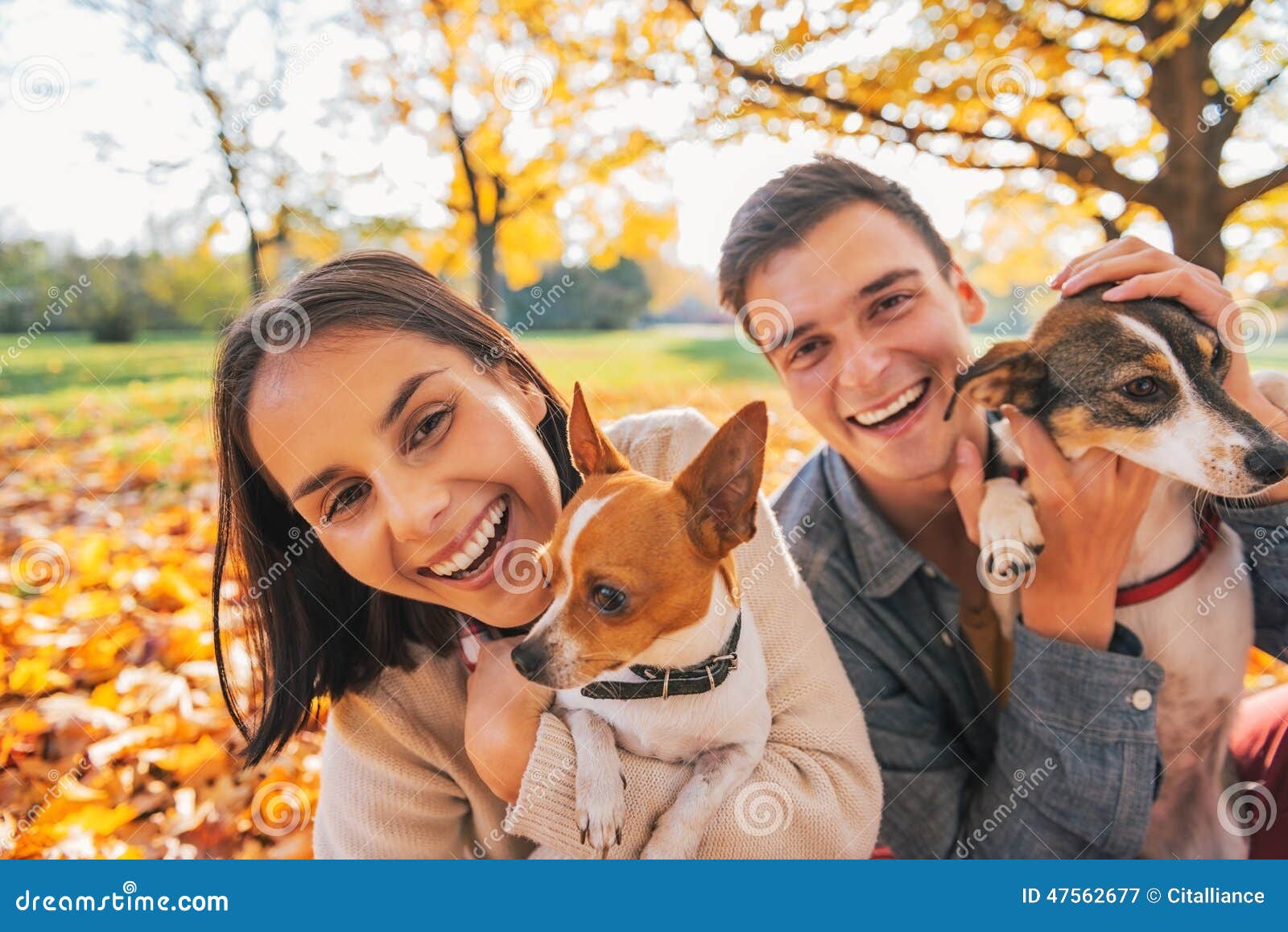 portrait of smiling young couple with dogs outdoors