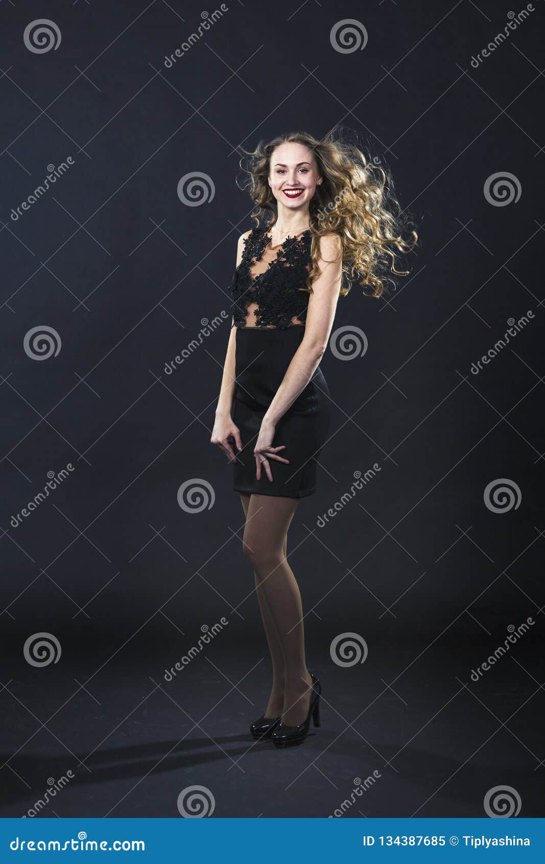 Portrait of a Smiling Young Girl in a Lace Dress on a Black Background ...