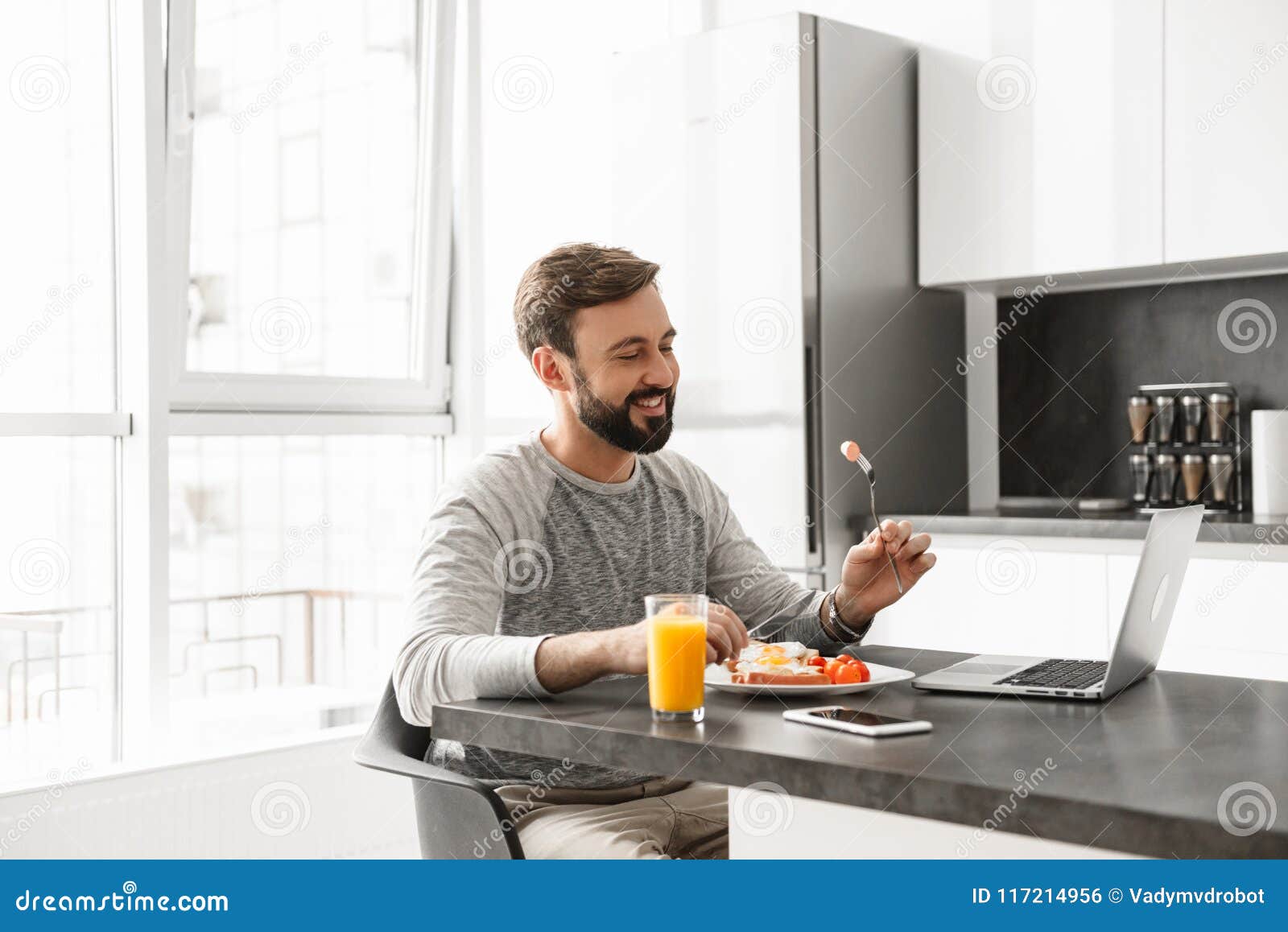 Portrait Of A Smiling Young Man Having Breakfast Stock Photo Image Of
