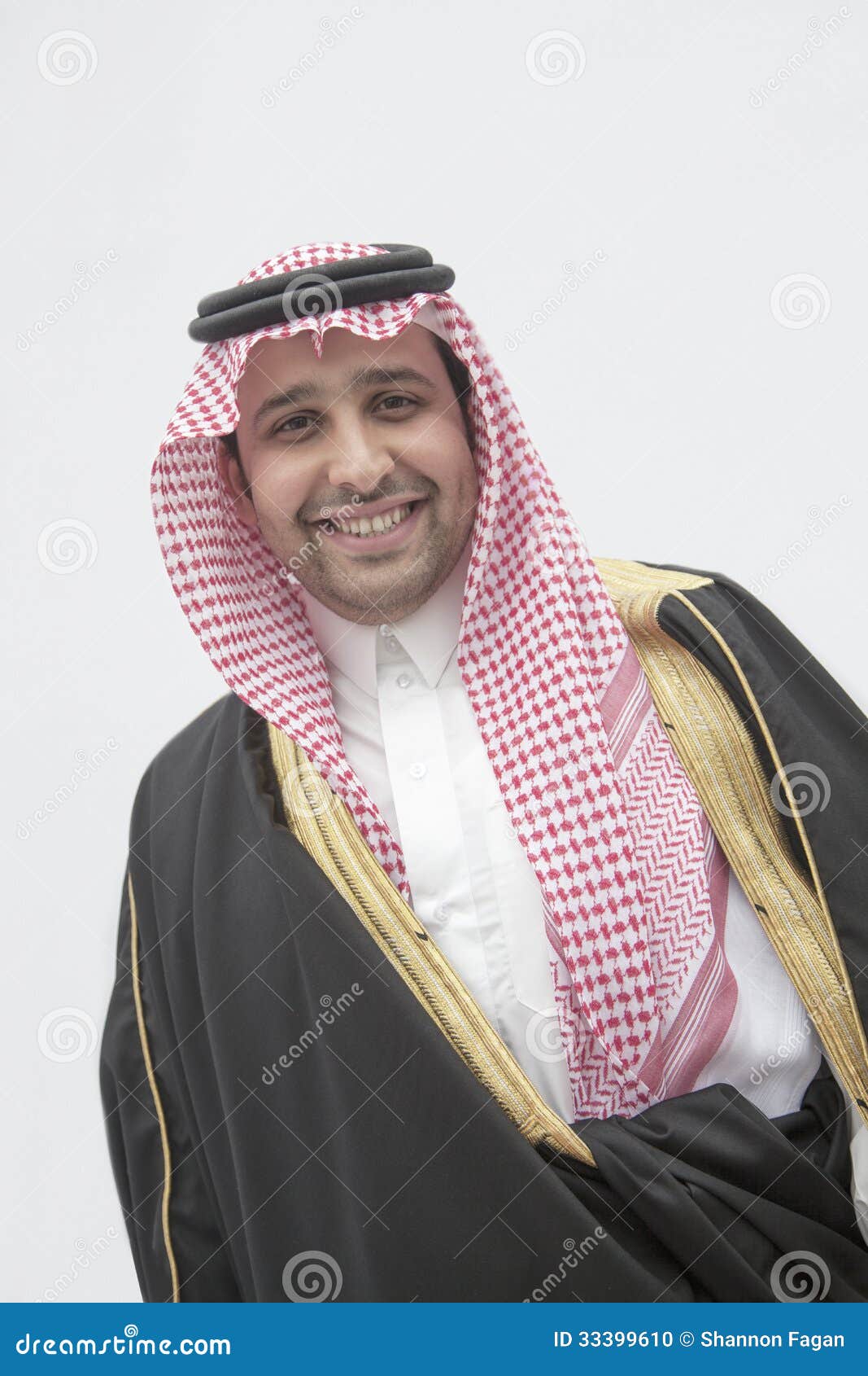 portrait of smiling young man in traditional arab clothing and