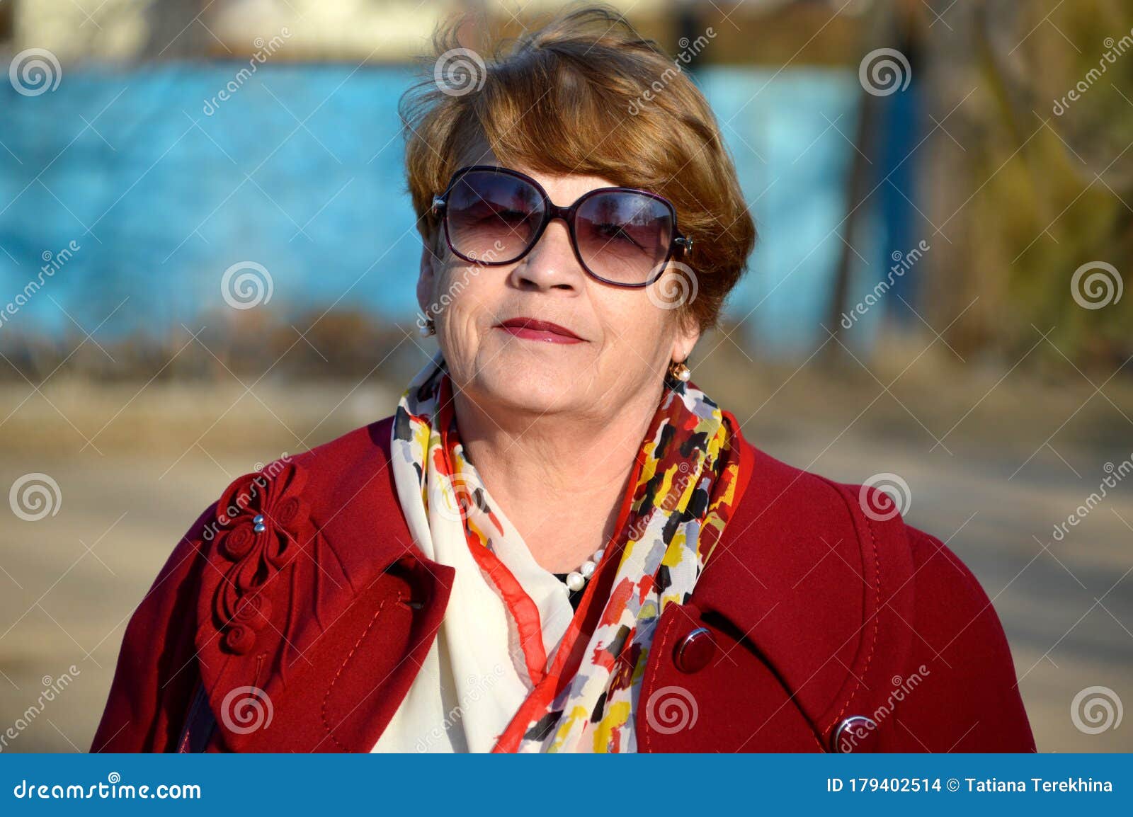 Portrait Of Stylish 67 Year Old Woman In A Bright Red Coat And