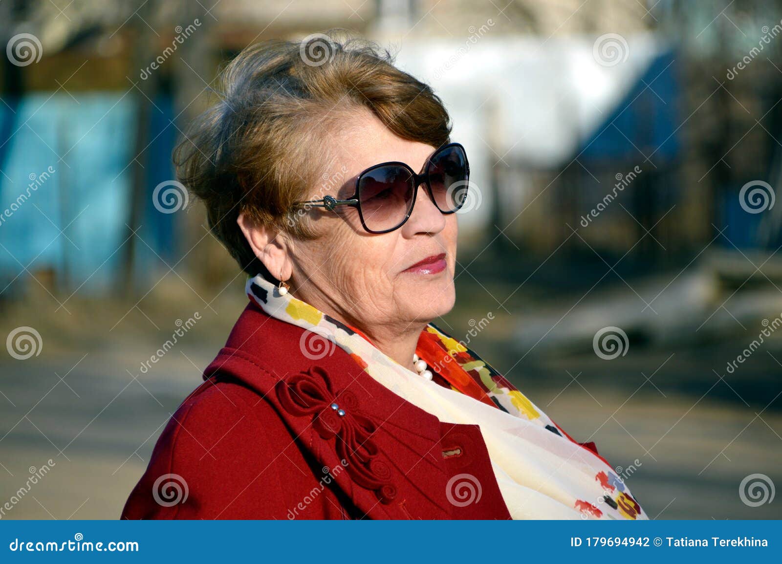 Portrait Of Stylish 67 Year Old Woman In A Bright Red Coat With