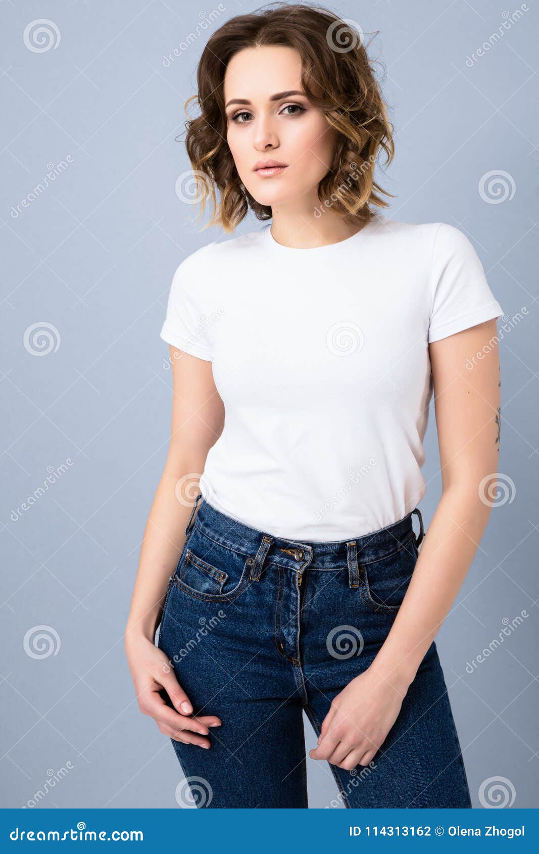 Stylish pretty girl in high-waisted jeans, white T-shirt and