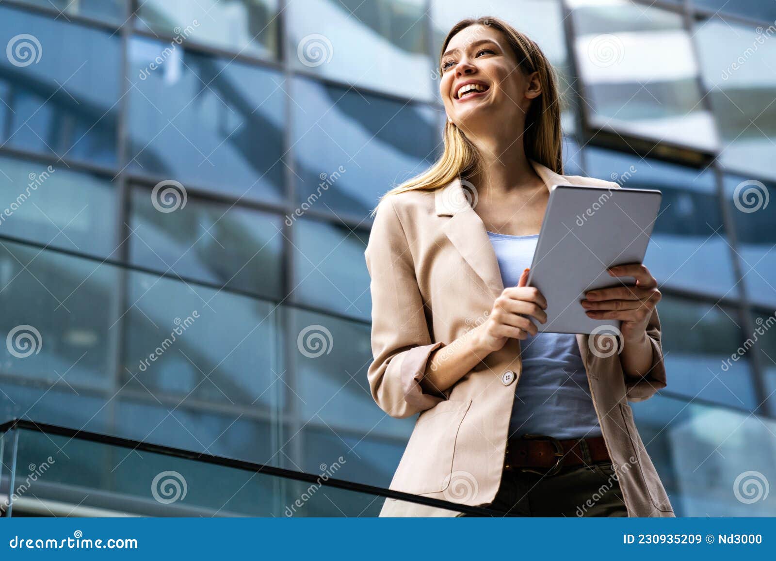 portrait of a successful business woman using digital tablet in front of modern business building
