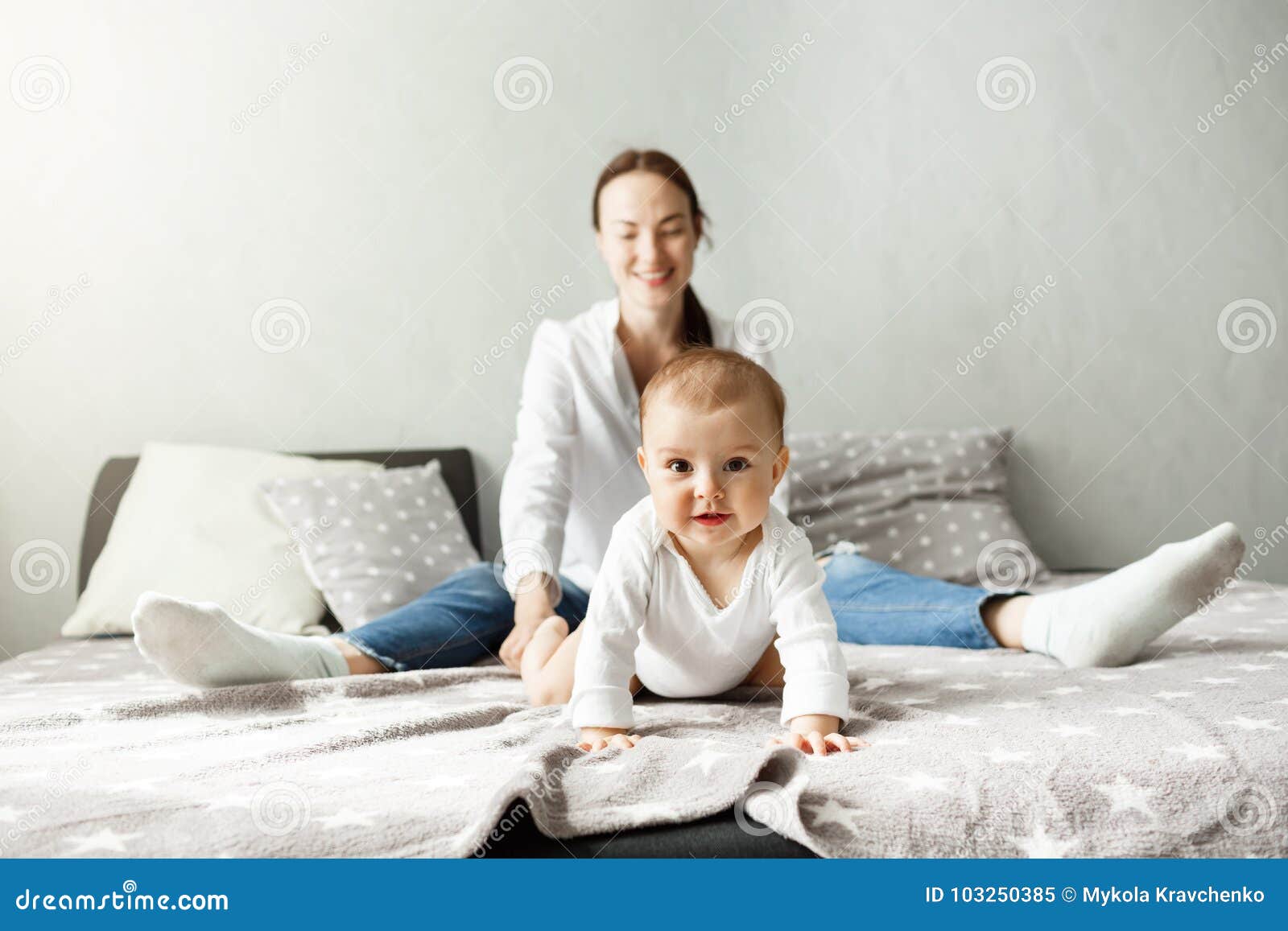 Portrait of Sweet Little Baby Sitting with Mother on Bed and Crawling ...