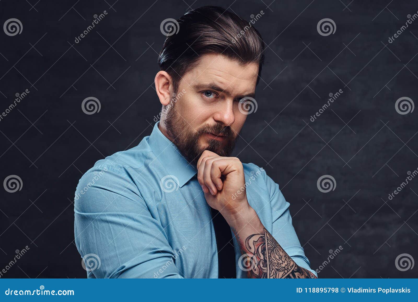 Portrait Of A Tattooed Handsome Middle-aged Man With Beard And Hairstyle Dressed In A Blue Shirt ...